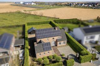 Gelegen in het charmante en landelijke Jeuk, een deelgemeente van Gingelom, bevindt zich deze uiterst kwalitatieve villa. De woning biedt een adembenemend vrij uitzicht en werd in 2005 gebouwd met oog voor duurzaamheid en energie-efficiëntie, waarbij uitsluitend gebruik is gemaakt van uiterst kwalitatieve materialen.<br /><br />De omgeving ademt rust en natuur, met uitgestrekte velden en een sfeervolle dorpskern in de nabijheid. Toch geniet u hier van een vlotte verbinding naar Sint-Truiden, Hasselt en de E40, waardoor steden als Brussel en Luik binnen handbereik liggen. Hier woont u in een oase van rust zonder in te boeten op bereikbaarheid en comfort.<br /><br />INDELING<br />Wanneer de dubbele elektrische poort zich opent, wordt u meteen betoverd door deze prachtige villa op een perceel van 1.250 m². De hoogwaardige afwerking straalt al van buitenaf: een perfect onderhouden tuin, een charmant aangelegd terras en een imposante gevel.<br /><br />Bij binnenkomst zet deze eerste indruk zich moeiteloos verder. De hal verwelkomt u met een luxueuze blauwe stenen vloer en een majestueuze eiken trap. De elegante boogvormige doorgangen geven een harmonieus karakter aan de woning.<br /><br />De woonkamer straalt warmte en gezelligheid uit, met (2 cm dik) eiken parket en een Hoog Rendement kachel van Flam. Grote ramen zorgen voor een overvloed aan natuurlijk licht en bieden toegang tot het overdekte terras, waar u in alle privacy kunt genieten van de tuin.<br /><br />De leefkeuken is een waar pronkstuk: een hoogwaardige Miele-uitrusting met onder andere een oven, steamer, koffiemachine en bordenwarmer. Het imposante werkblad van maar liefst 300 kg massief steen maakt deze keuken niet alleen stijlvol, maar ook bijzonder functioneel. Aangrenzend bevindt zich een ruime berging met ingebouwde kasten en een extra multifunctionele ruimte, momenteel ingericht als tweede keuken, maar perfect inzetbaar als bureau, extra slaapkamer of hobbykamer.<br /><br />Op de bovenverdieping treft u vier slaapkamers, allen met eiken parket. De master bedroom beschikt over een ruime privé dressing. De badkamer is voorzien van een dubbele wastafel, toilet en douche.<br /><br />De garage biedt niet alleen plaats aan uw wagen, maar beschikt tevens over een extra verdieping en een kelder met technische ruimte. De volledige woning is uitgerust met een geavanceerd alarmsysteem met 7 camera’s, rookdetectoren en luidsprekers in de woonkamer en keuken.<br /><br />AFWERKING<br />Deze villa onderscheidt zich door een uitzonderlijke materiaalkeuze, waaronder:<br />• Volle Franse eiken deuren en parket: Volle eik in alle binnendeuren en vloeren voor een warme en luxueuze uitstraling.<br />• Blauwe steen en kleiklinkers: Duurzaam en tijdloos, toegepast in de hal en tuin.<br />• Tropisch hardhout: Gebruikt voor de voordeur, luiken en garagepoort.<br />• Kwalitatieve keukens van Miele: Zowel in de hoofdkeuken als in de extra keuken.<br />• Technische topafwerking: Stookolie verwarming met Hoog Rendement ketel,<br />warmtepompboiler, 48 zonnepanelen (met groenestroomcertificaten - nog 8 jaar geldig) gescheiden riolering en een regenwaterput van 10.000 liter.<br /><br />INDELING PER VERDIEPING<br />Gelijkvloers:<br />• Ruime inkomhal met gastentoilet<br />• Woonkamer met HR kachel en toegang tot het overdekte terras<br />• Volledig uitgeruste leefkeuken<br />• Berging met ingebouwde kasten en aansluitingen voor wasmachine en droogkast (Miele droogkast aanwezig)<br />• Multifunctionele ruimte (momenteel tweede keuken)<br />• Prachtig afgewerkte garage met automatische poort en trap naar kelder<br /><br />Eerste verdieping:<br />• 3 ruime slaapkamers en 1 kleinere slaapkamer, alle 4 met eiken parket<br />• Dressing aan de master bedroom<br />• Badkamer met dubbele wastafel, toilet en douche<br /><br />Kelder:<br />• Extra bergruimte (ideaal voor wijnkelder - stabiele temperatuur)<br />• Technische ruimte (cv-installatie, warmtepompboiler, waterverzachter)<br />• Bovengrondse stookolietank met anti-lekvloer<br /><br />Buiten:<br />• Perfect onderhouden en volledig omheinde tuin<br />• Overdekt terras met zicht op het groen<br />• Bijgebouw voor extra opslagruimte<br /><br />Deze villa is een parel voor wie luxe, ruimte en privacy zoekt. Bovendien is de woning volledig instapklaar – alles wat u op de foto's ziet, inclusief meubels en verlichting, blijft aanwezig!<br /><br /><br />- Maatregelenregister : Er zijn geen maatregelen op dit perceel