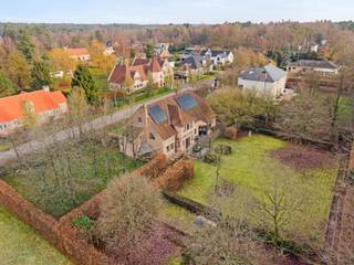 Deze tijdloze villa op een prachtig zuidgericht perceel van +/- 2.750 m² is residentieel gelegen in een doodlopende straat aan de rand van een natuurreservaat. De villa omvat een ruime woonkamer, een bureau, een gezellige leefkeuken, wasplaats, dubbele inpandige garage, 4 slaapkamers, ruime badkamer en zolderverdieping toegankelijk via een vaste trap.<br /><br />Gelijkvloers: <br />Royale inkomhal op natuurstenen vloer met gastentoilet. De woonkamer op massief eiken parket omvat een gezellige zithoek met gashaard en een aansluitende eetkamer. Af te sluiten bureauruimte op parket te bereiken vanuit de woonkamer. De landelijke leefkeuken met ontbijthoek en toegang tot het terras is compleet ingericht met apparatuur (vaatwasser, gaskookplaat, microgolfoven, heteluchtoven). Voorraadberging aanpalend de keuken aanwezig. De praktische wasplaats met zij-inkom is voorzien van ingemaakte kasten, spoelbak en aansluiting voor een wasmachine. De inpandige garage met plaats voor 2 wagens is voorzien van een automatische poort. Alle leefruimtes bieden een mooi uitzicht op de tuin en het achterliggende bosgebied.<br /><br />Verdieping: <br />De natuurstenen trap vanuit de inkomhal brengt ons naar de bovenverdieping. Hier treffen we 4 ruime slaapkamers op parket, waarvan 1 met aanpalende dressing. Deze dressing kan mogelijk omgevormd worden tot 5de slaapkamer. <br />De badkamer is uitgerust met ligbad, douche en dubbele lavabo in een stijlvol meubel. <br /><br />Een vaste trap geeft toegang tot de geisoleerde zolderverdieping. Hier kunnen mogelijk nog extra kamers of hobbyruimten worden gecreëerd.<br /><br />De tuin op het zuiden is rondom zeer verzorgd aangelegd en beschikt over een natuurstenen terras dat paalt aan de leefruimten zoals keuken en woonkamer. Achteraan volledige privacy en geen inkijk van achterliggende buren omwille van aanpalend natuurreservaat. <br /><br />Bijzonderheden: <br />- sublieme ligging in groene residentiele omgeving<br />- gunstige locatie tov Geel - Herentals <br />- kwaliteitsvolle afwerkingsmaterialen<br />- Recent aangelegde voortuin<br />- gunstig EPC - 145 kWh/m² - 16 zonnepanelen, vernieuwde gas HR-ketel, dak en gevel geïsoleerd, zoldervloer en plafond kruipkelder extra na-geïsoleerd