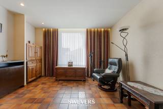 Voor meer info en foto’s, surf naar www.swevers.be – In de Sint-Albanusstraat 15 in Riemst vindt u deze halfopen bebouwing uit 1931 met een bewoonbare oppervlakte van ca. 120 m² op een perceel van 335 m². De woning is op te frissen, wat heel wat mogelijkheden biedt om ze volledig naar eigen smaak en volgens hedendaagse normen in te richten. Via de inkomhal komt u in de woonkamer van ca. 27 m², met aansluitend de eetkamer en de compacte, functionele keuken van ca. 4,80 m². Op het gelijkvloers zijn verder nog een badkamer, apart toilet, berging, een ruime werkplaats met drijfkracht aanwezig, ideaal als hobbyruimte, atelier of extra opslag. Op de eerste verdieping geeft de nachthal toegang tot 3 slaapkamers van ca. 7,50 m², 10,31 m² en 10,52 m². Daarnaast beschikt de woning over een kelder van ca. 8,48 m² en een zolder van ca. 30 m², wat extra bergruimte en bijkomend potentieel biedt. Een grote troef is de ruime garage van ongeveer 50 m², goed voor 2 wagens en extra stockageruimte. Ook de ligging is praktisch: winkels liggen op amper 700 meter, openbaar vervoer op 120 meter en scholen op 650 meter. Ontspanning vindt u op 450 meter en de snelweg bereikt u op 5,9 km. Deze woning vormt een interessante kans voor wie op zoek is naar een pand met karakter, ruimte en renovatiemogelijkheden op een vlot bereikbare locatie. Voor meer informatie, bel 011 255 155. Bron bewoonbare oppervlakte: EPC – verslag.