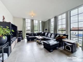 Dit lichtrijk appartement is gelegen nabij het centrum van Waardamme en geniet van uitzonderlijke woonvolumes.<br /><br />Het appartement bestaat uit een ruime inkomhal met gastentoilet, een ruime lichtrijke leefruimte met eet- en zithoek, een open ingerichte keuken (voorzien van keramische kookplaat, oven, microgolfoven, vaatwas en koelkast), een berging annex wasplaats, een badkamer met douche en drie ruime slaapkamers waarvan één voorzien van badkamer met bad en toilet. Het ruime zonneterras is achteraan het gebouw gelegen. <br /><br />Tot slot hoort er bij het appartement een privatieve kelderberging en een privatieve parkeerplaats.<br /><br />De ligging is centraal met verschillende winkels en diensten op wandelafstand gelegen in het centrum van Waardamme. Ook openbaar vervoer en verbindingswegen zijn zeer nabij. <br /><br />EPC: 127 kWh/m²<br /><br />