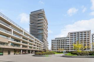 Zee, jachthaven, de torens van de Sint-Petrus en Sint-Pauluskerk — het panorama vanuit dit hoekappartement op de negende verdieping van Sky Tower 2 laat niemand onbewogen. Dag na dag een ander schouwspel. Elke blik naar buiten zorgt voor een grenzeloze verwondering.<br /><br />De 103 m² bieden ruimte zonder compromis. Een royale inkomhal met apart gastentoilet geeft toegang tot de lichtrijke leefruimte met open keuken, omsloten door floor-to-ceiling glasgevels aan twee zijden. Zon stroomt binnen van de middag tot de avond, en met het 39 m² terras vervagen de grenzen tussen binnen en buiten volledig. Aan weerszijden van de leefruimte bevindt zich een volwaardige 2-persoonsslaapkamer, elk met een eigen privébadkamer.<br /><br />De afwerking is luxueus met hoogkwalitatieve materialen: parket in de leefzones, solide vloeren en tegels in keuken en badkamers, vloerverwarming op afstand bedienbaar met aansluiting op het warmtenet. Comfort en duurzaamheid als evidentie. Het gebouw beschikt bovendien over een fietsenstalling en huisvuillokaal.<br /><br />Door te wonen op hoogte ervaar je de rust van het grenzeloos uitzicht enerzijds én de energie van de bruisende stad anderzijds — kortom, eindeloze verwondering.<br /><br />De voorgestelde prijs is excl. 21%btw. De foto's met meubilair zijn visualisaties ter illustratie.<br /><br />Er zijn geen maatregelen gevonden op dit kadastraal perceel volgens onze opvraging bij het Maatregelenregister. <br /><br />Interesse in dit TOP-appartement?<br />Contacteer Katrien via 0477 46 53 11 of via e-mail: katrien@waeyler.be.