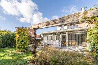 <p><span>Dit halfopen woonhuis in Gooreind, een deelgemeente van Wuustwezel, presenteert zich als een unieke, architecturale woning met een opvallend modern ontwerp en een uitstekende ligging. De woning combineert op een slimme manier de privacy van een gezinshuis met de openheid en het licht van moderne architectuur.</span></p>
<p><span>De centrale leefruimte is opvallend ruim en geniet dankzij een brede raampartij van veel natuurlijke lichtinval, wat zorgt voor een zonnige en open sfeer. De ruimte is naadloos verdeeld in een comfortabele zithoek en een eetgedeelte. De halfopen keuken, strak uitgevoerd in donkergrijze tinten met houten accenten, is voorzien van diverse inbouwapparatuur en is perfect geïntegreerd in de leefruimte. De gehele begane grond is voorzien van een lichte vloer uit natuursteen. In de woning naast de inkomhal de ruime inpandige garage.</span></p>
<p><span>De woning beschikt over drie ruime slaapkamers, waarvan één unieke zolderkamer met een gelakte houten vloer met warme uitstraling en een hoog plafond. Daglicht stroomt hier binnen via dakvlakvensters en een hoge wand van glazen bouwstenen, wat zorgt voor een unieke en lichte sfeer. De twee overige slaapkamers bevinden zich op de eerste verdieping waar ook het toilet en de afzonderlijke badkamer met douche en bad zich bevindt.</span></p>
<p><span>Buiten beschikt het pand over een goed onderhouden tuin, afgeschermd door een dichte haag en liggend naast de woning met zicht op omliggende bebouwing. De voorgevel, met zijn opvallende puntgevel en lichte afwerking, onderscheidt zich duidelijk van de omgeving en biedt privacy door de lage heggen langs de straat.</span></p>
<p><span>Deze woning, met een bruikbare vloeroppervlakte van 217 m², heeft een gunstig energielabel B (184 kWh/(m² jaar)). Met een centrale verwarming via een condenserende ketel op gas, ligt deze score al onder het gemiddelde voor halfopen bebouwingen. </span></p>
<p><span>Dit is een ideale woning voor wie op zoek is naar een lichte, ruime en architectonisch interessante halfopen bebouwing op een goede locatie in Gooreind/Wuustwezel. De gunstige ligging ten opzichte van Gooreind centrum en Brasschaat maakt dit een praktische en aangename gezinswoning.</span></p>
Interesse in uitbreiding?<span> Het is mogelijk om een naastliggend bouwperceel met een oppervlakte van 335m² bij aan te kopen. Vraagprijs voor het perceel bedraagt 160.000€.</span>