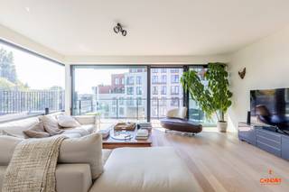 Dit modern appartement is gelegen aan <strong>het Bloemekenspark</strong>, op een steenworp afstand van het bruisende centrum van Gent, biedt een goede bereikbaarheid via belangrijke invalswegen, lokale handelaars en het openbaar vervoer op wandelafstand. Op de site geniet u van <strong>alle rust in het groen</strong>! <br /><br />Het appartement maakt deel uit van de <strong>residentie Tribeca 2-3-4</strong>. Via de gemeenschappelijke inkomhal gaat u naar het derde verdiep, met lift of trap, naar het privatieve appartement. U komt binnen via een inkomhal met apart bezoekerstoilet waarna u de ruime en lichtrijke woonkamer betreedt. Hier heeft u zicht op de site en de woonkamer is voorzien van een <strong>eerste zuidgeoriënteerd terras</strong>. Verder gaat u naar de open eetkamer met in het verlengde de volledig geïnstalleerde keuken. Aan de keuken werd een praktische berging voorzien met aansluiting voor wasmachine. Van hieruit betreedt u het tweede <strong>immense terras</strong> met zicht op het Bloemekenspark. <br /><br />Een verdiep lager, op het tweede verdiep, vindt u de badkamer met ligbad en toilet en <strong>twee slaapkamers</strong>. De slaapkamers geven opnieuw uit op een derde zuidgeoriënteerd terras. In de kelderverdieping heeft u nog een privatieve autostaanplaats en privatieve berging. <br /><br />Wenst u dit ruime appartement te bezichtigen? Neem gerust contact op via 09 278 88 88 voor het maken van een afspraak. 