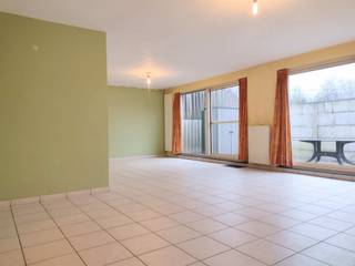 Ruim, lichtrijk, gelijkvloers appartement met groot terras, zuid-west georiënteerd.INDELING:Inkomhal met glazen deuren naar de ruime leefruimte met...