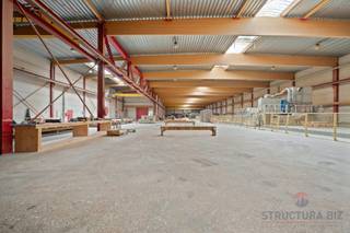 *** onder option***Het gebouw bestaat uit een opslagruimte van +/- 2.640 m² met een vrije hoogte van 8 m. Het is uitgerust met een rolbrug en...