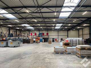 Magazijn met overdekte laadkade te huur op industriezone Driehoek in Balen. Het magazijn heeft een vloeroppervlakte van 1.394m2 met een verdiepingsvloer van 146m2 die voorzien is van goederenlift. <br /><br />Het gebouw is opgetrokken in staalconstructie en geïsoleerde panelen met vrije hoogte 6,5m en beschikt over industriële betonvloer, automatische sectionaalpoort (4,5m x 5m), laadkade brandklasse B en voldoende stroomvoorzieningen (220V/380V). Vooraan is er voldoende manoeuvreerruimte en parkeergelegenheid. <br /><br />Huurprijs excl. BTW en gemeenschappelijke kost van €75,- per maand. Onmiddellijk beschikbaar! <br /><br />BIJZONDERHEDEN:<br />- Overdekte laadkade aanwezig<br />- Open indeling zonder peilers<br />- Vrije hoogte 6,5m<br />- Onmiddellijk beschikbaar!