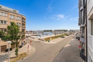Charmant appartement met 2 slaapkamers aan de jachthaven van Zeebrugge
Dit charmante appartement is uitstekend gelegen aan de jachthaven van Zeebrugge, in de Tijdokstraat. Dankzij de zuidwestelijke oriëntatie geniet u van veel natuurlijke lichtinval en een prachtig uitzicht op de jachthaven en de aangemeerde bootjes.
Bij het betreden van het appartement komt u in de inkomhal, die toegang geeft tot de lichtrijke leefruimte met een halfopen, volledig uitgeruste keuken. Aansluitend bevinden zich zowel een balkon als een ruim terras, waar u in alle rust kunt genieten van het schitterende uitzicht op de jachthaven.
Verder beschikt het appartement over een praktische berging en een afzonderlijk gastentoilet.
De nachthal leidt naar twee volwaardige slaapkamers, beide voorzien van ingemaakte kasten. De badkamer is uitgerust met een dubbele lavabo, een ligbad met douchewand en een tweede toilet.
Als extra troeven beschikt het appartement over twee fietshaken en een privatieve berging.
Bent u op zoek naar een instapklaar appartement op een toplocatie aan de kust, met een zonnige oriëntatie en een uniek uitzicht? Dan is dit appartement beslist een bezoek waard.
Ben jij op zoek naar een appartement op een perfecte locatie in Zeebrugge? Contacteer makelaar Stéphanie 0472 77 86 60 of stephanie@keyimmo.be voor meer info of een bezoek.