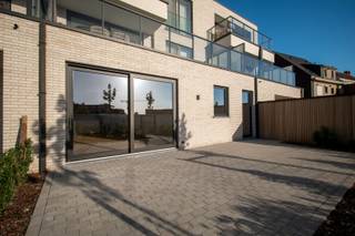 Volledig afgewerkt en instapklaar appartement met ruim terras en privatief tuintje.<br />Oplevering bij akte.<br /><br />Indeling: er is een inkomhal die toegang geeft tot een aparte berging, toilet en keuken. Via de open keuken heb je overigens toegang tot de lichtrijke leefruimte, terras en tuin. Daarnaast is er ook een nachthal die toegang geeft tot het de badkamer en de twee slaapkamers. De badkamer bestaat uit een inloopdouche en een dubbele lavabo.<br /><br />Alle muren en plafonds twee-laags opgeschilderd, mdf plinten en deuren geschilderd.<br /><br />Volledig instapklaar afgewerkt!<br /><br />De bewoonbare oppervlakte bedraagt 102,00 m². De oppervlakte van het terras bedraagt 32 m².<br /><br />Op de zijkant van het gebouw bevinden zich de bergingen. Bij appartement 0.1 hoort berging 7. Achteraan zijn de garageboxen met een oppervlakte van 18m², voorzien van een manuele sectionale poort. Kan geautomatiseerd worden, voorzieningen voor het plaatsen van een laadpaal zijn ingewerkt.<br /><br />Er is een afgesloten gemeenschappelijke fietsenberging voorzien, bruikbaar voor alle bewoners.<br /><br />De prijs van de berging bedraagt 6.300,- euro. <br /><br />E-peil 10 (100% vrijstelling op onroerende voorheffing voor 5 jaar). Er zijn 4 zonnepanelen (435 Wp/st) geplaatst en inbegrepen. Uitbreiding PV installatie mogelijk zodat E-peil 10 gehaald wordt met volledige vrijstelling van onroerende voorheffing voor 5 jaar.<br /><br />Warmtepomp (lucht/water) met vloerverwarming met apart regelbare circuits per ruimte.<br /><br />Alle bedragen zijn exclusief garages, bergingen en alle kosten. De berging dient mee aangekocht te worden. <br /><br />Prijs voor het appartement met garage en berging is 383.604,- euro (exclusief registratie, notaris, btw en aansluitingskosten). Opsplitsing als volgt: grondaandeel 77.682,- euro, constructiewaarde 305.922,- euro.<br /><br />AANKOOP AAN 6% BTW OP CONSTRUCTIE MOGELIJK: zowel voor eigen bewoning als bij engagement tot lange verhuur (minstens 15 jaar)<br /><br />OPENDEUR OP ZATERDAG 24/10 VAN 9U-12U30<br />==> inschrijven kan via de website of via xavier@opt-immo.be - 0491 33 66 29