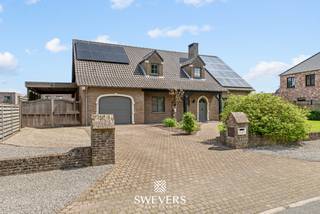 Voor meer info en foto’s, surf naar www.swevers.be – Deze ruime open bebouwing in een rustige straat in Hechtel-Eksel biedt maar liefst 282 m² bewoonbare oppervlakte op een perceel van 14a 15ca. De woning uit 1992 combineert veel leefruimte met een praktische indeling en werd recent opgewaardeerd met onder andere een nieuwe stookolieketel, zonnepanelen, vernieuwde garagepoort en Siemens-toestellen in de keuken. Op het gelijkvloers vindt u een lichtrijke woonkamer van 38 m² met airco, een ruime keuken van 20 m² met toegang tot het terras, een eerste slaapkamer van ca. 16 m², een berging en een apart gastentoilet. De inpandige dubbele garage van 48 m² biedt plaats voor twee wagens en extra stockage. De eerste verdieping telt vier bijkomende slaapkamers, waaronder twee zeer ruime kamers van ca. 32 m² en 28 m². Eén slaapkamer beschikt over airco. De badkamer is uitgerust met een ligbad, dubbele wastafel en toilet, aangevuld met een tweede inloopdouche. Daarnaast is er een ruime kelder van 61 m² en veel zolderruimte voor extra opslag. Buiten geniet u van een groot perceel met een terras van ca. 30 m² en een verzorgde tuin met veel mogelijkheden. Scholen, winkels, openbaar vervoer en ontspanning liggen vlakbij. Ook Nationaal Park Bosland en “Fietsen door de Bomen” bevinden zich in de omgeving. Voor meer informatie, bel 011 255 155. Bron bewoonbare oppervlakte: EPC – verslag.