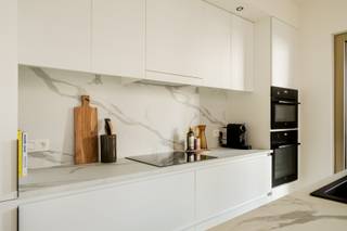 NIEUW ZUID nieuwbouwappartement 3 slpk, 2 badk & ruim terras<br /><br />Dit verfijnde nieuwbouwappartement (verkoop onder registratierechten) op de eerste verdieping van het prestigieuze BAN-project biedt een unieke woonervaring. Het gebouw, ontworpen door Japans toparchitect Shigeru Ban (Pritzker Prize 2014), is een zeldzame realisatie in België en wordt gekenmerkt door zijn houten gevel en samenspel tussen architectuur en natuur.<br /><br />De inkomhal, met apart gastentoilet en ruime berging voorzien van aansluiting voor wasmachine en droogkast, leidt naar een lichtrijke en open leefruimte. Grote raampartijen zorgen voor een overvloed aan natuurlijk licht en geven uit op een royaal zuidgeoriënteerd terras van 20m² — een perfecte plek om in alle rust te ontspannen met zicht op de groene binnentuin.<br /><br />De leefruimte sluit naadloos aan op de open keuken, volledig uitgerust met kwalitatieve AEG-toestellen: inductiekookplaat, heteluchtoven en combi-oven, vaatwasser en grote koelkast met aparte diepvriezer. Dankzij het ruime eiland is de keuken zowel functioneel als bijzonder uitnodigend.<br /><br />De master slaapkamer beschikt over een ensuite badkamer met inloopdouche en toilet en biedt eveneens directe toegang tot het terras. Achteraan bevinden zich nog twee bijkomende slaapkamers en een tweede volwaardige badkamer met douche, bad en dubbele lavabo.<br /><br />Ondergrondse parkeerplaats met individuele laadpaal verplicht mee aan te kopen (€45.000)<br /><br />Gelegen in Nieuw Zuid — een van de meest vernieuwende en duurzame stadsontwikkelingen van België — geniet u van een woonomgeving waar stadsleven en rust samenkomen. <br /><br />Troeven:<br />- Nieuwbouwappartement met verkoop onder registratierechten<br />- 3 volwaardige slaapkamers en 2 volwaardige badkamers<br />- Ruim zuidgeoriënteerd terras (20m²) met zicht op rustgevende binnentuin<br />- Ondergrondse parkeerplaats met individuele laadpaal (€45.000)<br />- Ruime ondergrondse fietsenstalling aanwezig<br /><br />Afspraak maken kan via:<br />Contactformulier of e-mail naar nicolevangoethempad80@gmail.com