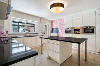 Bent u op zoek naar een ruime gezinswoning waar ruimte en een prachtige tuin samenkomen? Dan zal deze halfopen woning in de Kortewagenstraat u ongetwijfeld weten te bekoren.<br />Deze charmante woning geniet van een uitstekende bereikbaarheid en een perceel van 1.595 m² met een zonnige zuid gerichte tuin waar rust en privacy centraal staan.<br /><br />Via de inkomhal betreden we de woning. De ruime leefruimte is heel lichtrijk door de grote raampartijen en biedt alle ruimte voor een gezellige zithoek en een royale eetplaats. De aanwezige houtkachel zorgt tijdens de wintermaanden voor extra sfeer en gezelligheid.<br />Aansluitend bevindt zich de moderne, volledig uitgeruste keuken met kookeiland, hoogwaardige toestellen en voldoende werk- en bergruimte. Vanuit de keuken bereikt u de berging/wasplaats en prachtige veranda, die het hele jaar door een heerlijke extra leefruimte vormt en een mooi zicht biedt op de tuin.<br />Verder beschikt het gelijkvloers over een douchekamer, bureauruimte of extra slaapkamer en een afzonderlijk toilet.<br /><br />Op de verdieping bevinden zich vier volwaardige slaapkamers en een ruime badkamer met dubbel lavabomeubel, ligbad en inloopdouche, waardoor deze woning perfect geschikt is voor grotere gezinnen of mensen die gewoon graag veel ruimte hebben.<br /><br />Buiten wordt het plaatje compleet. De zonnige tuin vormt een groene oase met een vijver en een gezellige overdekte loungehoek waar het heerlijk vertoeven is met familie en vrienden.  Aan de woning is er ook nog een deels bovengronds geplaatst zwembad, welke te renoveren of te verwijderen is.  Aansluitend aan de woning is er een ruime vrijstaande dubbele garage met extra zolderberging, ideaal voor wie nood heeft aan veel opslagruimte, een werkplaats of hobbyruimte.<br /><br />Met een bewoonbare oppervlakte van ca. 250 m², een gunstig EPC van 180 kWh/m² (label B) en een ruim perceel biedt deze woning een mooie combinatie van ruimte, comfort en woonkwaliteit. De huidige stookolieketel dient vervangen te worden, waardoor u de mogelijkheid heeft om meteen te kiezen voor een moderne en energiezuinige verwarmingsinstallatie.<br /><br />Ook zijn er nog 18 zonnepanelen aanwezig van +/- 4000 Wp met nog een 6 tal jaar groenstroomcertificaten van 230 euro per 1000 Wp<br /><br />Bent u op zoek naar een instapklare gezinswoning met een grote tuin, veel leefruimte en een grote garage/berging? Mail ons naar info@loimmo.be voor een bezoek.
