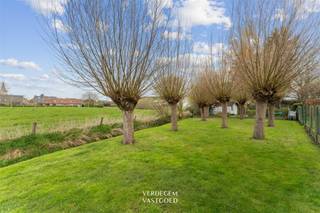 <p><span>Ligging<br /></span><span>Ontdek deze woning in hoevestijl die zich situeert tussen Nevele en Vosselare.<br />Verschillende lokale voorzieningen, zoals winkels, supermarkten, scholen, bakker en slager bevinden zich op wandelafstand.<br />Ook Gent is makkelijk te bereiken via E40 en openbaar vervoer (bus, trein).<br /><br /></span><span>Woning in hoevestijl met schuur, 3 slaapkamers en mooie tuin<br /></span><span>Deze charmante woning vindt haar oorsprong in een authentieke Vlaamse hoeve.<br />Achter de gevel schuilt een thuis waar sfeer en ruimte hand in hand gaan. <br />De grote voortuin is een prachtig visitekaartje voor wie houdt van landelijk wonen, een plek voor fruitbomen of grazende schaapjes.<br />Ook in de achtertuin, met een praktisch schuurtje inclusief garage, geniet je van een uitzicht dat blijft inspireren.<br />Vanop het terras geniet je van de omliggende weilanden, met de kerktoren van Nevele als herkenningspunt in de verte.<br /><br />Binnen word je verwelkomd in een ruime leefruimte met gaskachel. <br />De aansluitende keuken met ontbijtplek nodigt uit tot lange ochtenden met het gezin.<br />Verder op het gelijkvloers een badkamer, nachthal, twee volwaardige slaapkamers en een wasplaats/berging.<br />Op de verdieping bevindt zich een derde, ruime slaapkamer en een grote zolder, die tal van mogelijkheden biedt voor wie extra ruimte wenst.<br /><br /></span><span>Troeven<br /></span><span>/ ligging<br />/ tuin met unieke zichten<br />/ charme en sfeer<br />/ schuur of atelier<br /><br /><br /></span></p>
