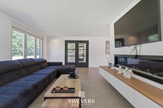 Voor meer info en foto’s, surf naar www.swevers.be – Deze ruime open bebouwing in de Sint-Bernardusstraat in Hechtel-Eksel biedt een unieke combinatie van comfort, moderne technieken en uitzonderlijk veel buitenruimte op een perceel van meer dan 1 hectare. De woning werd grondig vernieuwd in 2020 en beschikt over een bewoonbare oppervlakte van ca. 382 m². Dankzij de praktische indeling, zes slaapkamers en de volledig onderkelderde woning is dit een ideale thuis voor grote gezinnen, zelfstandigen of liefhebbers van ruimte en rust.<br />De lichtrijke leefruimte van ca. 50 m² sluit mooi aan op de ruime keuken van 28,53 m² met kwalitatieve toestellen, waaronder twee grote koelkasten, een teriyaki plaat, een Quooker kraan, inbouwkasten,… . Op het gelijkvloers bevinden zich verder de masterbedroom met ensuite dressing en badkamer let dubbele douche, aparte wasruimte en een ruime aansluitende garage van 38 m². Op de verdieping zijn nog vijf volwaardige slaapkamers en een extra badkamer aanwezig.<br />De woning is uitgerust met domotica, zonnepanelen, stormdak en drijfkracht, ideaal voor een elektrische laadpaal of zwaardere machines. De volledige kelder van ca. 92 m², zolderruimte en meerdere bergingen zorgen voor bijzonder veel opslagmogelijkheden. Daarnaast beschikt het perceel over een vrijstaande hangar van ca. 130 m² met elektriciteit en warm water, ideaal voor opslag, hobby’s of paardenstallen.<br />Buiten geniet u van een zuidgericht terras en een enorm perceel waar rust, privacy en buitenleven centraal staan. Bovendien worden quasi alle aanwezige roerende goederen mee verkocht, uitgezonderd de bedden.<br />Rustig gelegen in een groene omgeving en toch vlot bereikbaar nabij scholen, winkels, openbaar vervoer en invalswegen. Voor meer informatie, bel 011 255 155. Bron bewoonbare oppervlakte: EPC – verslag.