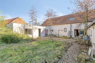 Op een uitzonderlijke ligging, vlakbij de prachtige Merelbeekse Bossen en tussen de charmante dorpen Melsen en Munte, bevindt zich deze karaktervolle hoeve op een ruim perceel van maar liefst 935 m², gelegen in woongebied met landelijk karakter. Hier geniet je van rust, natuur en ruimte, terwijl je toch vlot verbonden blijft met de omliggende gemeenten. BEZOEKMOMENT ZATERDAG 28/03 OP AFSPRAAK - 0475/20.55.35. De woning, oorspronkelijk gebouwd in 1850, beschikt over een bewoonbare oppervlakte van ca. 235 m² en biedt een unieke combinatie van authenticiteit en renovatiepotentieel. Dit pand vormt de ideale basis voor wie droomt van een karaktervolle woning die volledig naar eigen smaak kan worden ingericht. Het perceel beschikt vandaag reeds over ruime parkeermogelijkheden en biedt bovendien diverse mogelijkheden voor verdere optimalisatie en herinrichting, eventueel na afbraak van de bestaande bebouwing, met het oog op het realiseren van twee halfopen woningen conform de geldende bouwvoorschriften. Dit pand is een totaal renovatieproject en vormt een buitenkans voor handige kopers, investeerders of liefhebbers van authentieke hoeves die hun eigen woonverhaal willen creëren op een toplocatie. Gelijkvloers: via de inkomhal betreed je de ruime leefruimte waar licht en ruimte centraal staan. Verder bevinden zich op dit niveau twee geïnstalleerde keukens, twee badkamers (beide voorzien van ligbad, lavabo en toilet), één slaapkamer in het zijgedeelte en een praktische berging achteraan. Eerste verdieping: de eerste verdieping omvat één slaapkamer en biedt daarnaast nog meerdere open ruimtes die verder afgewerkt kunnen worden tot extra slaapkamers, een bureau of hobbyruimte. <br />Troeven:<br />- Rustige topligging tussen Melsen en Munte, vlakbij de Merelbeekse Bossen<br />- Ruim perceel van 935 m² met zuidwestgerichte tuin<br />- Karaktervolle hoeve van 235 m² met tal van mogelijkheden<br />Bent u net zoals ons gecharmeerd door deze knappe hoeve? Contacteer ons!