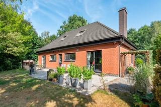 <p>Deze gerenoveerde woning bevindt zich op een royaal perceel van maar liefst 2.148 m². Tussen 2025 en 2026 werd het eigendom grotendeels vernieuwd. Zo geniet u van hedendaags comfort in een groene omgeving.<br /><br />Bij binnenkomst komt u in een ruime inkomhal dewelke toegang geeft tot de leefruimte en de gezellige keuken. De nieuwe Dovy keuken is voorzien van alle hedendaags comfort. Deze keuken biedt toegang tot het terras alsook de prachtige zonovergoten tuin. <br />De diepe tuin biedt veel privacy. Bovendien bevindt zich in de tuin een ruim bijgebouw dat perfect dienst kan doen als atelier, werkplaats, hobbyruimte of tuinberging.<br />Een leuk detail: via een poortje achteraan de tuin wandelt u rechtstreeks het bos in richting de Vlaspoel en het Zevenbergenbos.<br /><br />De woning beschikt over drie volwaardige slaapkamers, waarvan één (14m²) op de gelijkvloerse verdieping met een eigen ensuite badkamer. Deze indeling biedt interessante mogelijkheden voor onder meer kangoeroewonen, co-housing of een praktijk aan huis. Er is verder ook een inpandige garage alsook een kelder aanwezig. <br />De garage beschikt over een laadpunt voor elektrische wagens, thuisbatterij, ketel en omvormer voor de zonnepanelen. <br />Op de gelijkvloerse verdieping kan u nog een handig gastentoilet terugvinden.<br /><br />Op de eerste verdieping zijn de overige 2 slaapkamers gelegen (16 m² en 8 m²). Beide kamers beschikken bovendien over een ensuite dressing. (niet opgenomen in voornoemde m²)<br />De dressing van de kleinste kamer wordt op heden gebruikt als hobbyruimte. <br />Eveneens kan u op deze verdieping een tweede badkamer terugvinden dewelke voorzien is van een inloopdouche, lavabomeubel en tweede toilet. <br /><br />Ook op vlak van duurzaamheid scoort deze woning uitstekend dankzij de aanwezigheid van zonnepanelen, een thuisbatterij, een laadpunt voor een elektrische wagen, warmtepompboiler en een regenwaterput (3.000 liter).<br /><br />Pluspunten: <br />+ prachtig perceel van 2.148 m²<br />+ 3 slaapkamers<br />+ conforme elektrische keuring<br />+ alarm aanwezig (ook camerabewaking)<br />+ zonnepanelen, thuisbatterij en laadpunt aanwezig<br />+ gerenoveerd in 2025-2026: nieuwe ramen, ketel, dak, badkamer, ... <br />+ regenwaterput 3000 liter<br />+ ruim zonneterras<br />+ ruim bijgebouw<br />+ Rechtstreekse toegang tot het bos<br />+ mogelijkheid tot co-housing of kangoeroewonen<br /><br />Bent u op zoek naar een instapklare woning met veel ruimte, een prachtige tuin en zicht op groen? Dan is deze eigendom beslist een bezoek waard. Wij zijn bereikbaar via het nummer 03 337 50 70 of info@vbvastgoed.be.</p>