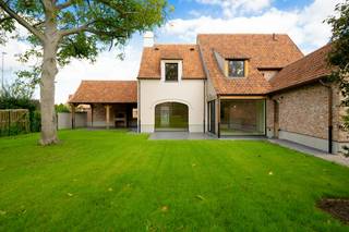Op een prominente hoeklocatie in het bosrijke Hertsberge bevindt zich deze vrijstaande landelijke woning, afgewerkt met oog voor authentiek vakmanschap en eigentijds comfort. De karaktervolle gevels met eiken accenten en stijlvolle raampartijen geven het pand een unieke uitstraling. Met de uitgestrekte bossen van het Landschapspark Bulskampveld vlakbij en een snelle verbinding richting Oostkamp, Brugge en de E40, geniet u hier van een ideale balans tussen groen wonen en een vlotte bereikbaarheid.<br /><br />Bij binnenkomst leidt de centrale inkomhal met gastentoilet naar een ruime, afzonderlijke bureauruimte en de royale, lichtrijke leefruimte waar een warme parketvloer en grote, gebogen raamsecties de toon zetten. De leefruimte vloeit moeiteloos over in de strakke eilandkeuken, die uitgerust is met hoogwaardige greeploze kasten en inbouwapparatuur. Een absolute blikvanger bevindt zich direct buiten: via de brede raampartijen stapt u op het zonnige terras of onder het overdekte terras, waar de eiken spanten en de robuuste bakstenen buitenhaard het hele jaar door uitnodigen tot sfeervol buitenleven.<br /><br />De bovenverdieping is doordacht ingedeeld en strak afgewerkt met dezelfde kwalitatieve houten vloerbedekking. Hier bevinden zich drie volwaardige, lichtrijke slaapkamers. Sfeervolle dakkapellen zorgen in elke kamer voor een aangename lichtinval en een mooi zicht op de omgeving. <br /><br />Algemene info: <br />- Onmiddellijk beschikbaar<br />- 3/4 slaapkamers<br />- 1 parkeerplaats<br />- Epc in opmaak<br />- €2.400,00/maand<br />- Ruime tuin met pracktisch en ruim tuinhuis. <br /><br />De snelste manier om een bezoek te brengen aan deze woning? Vraag je bezoek aan via de roze knop op onze website (www.dewaele.com) en je wordt gecontacteerd door onze verhuurexpert.
