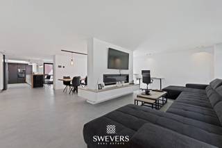 Voor meer info en foto’s, surf naar www.swevers.be – Deze ruime open bebouwing in de Sint-Bernardusstraat in Hechtel-Eksel biedt een unieke combinatie van comfort, moderne technieken en uitzonderlijk veel buitenruimte op een perceel van meer dan 1 hectare. De woning werd grondig vernieuwd in 2020 en beschikt over een bewoonbare oppervlakte van ca. 382 m². Dankzij de praktische indeling, zes slaapkamers en de volledig onderkelderde woning is dit een ideale thuis voor grote gezinnen, zelfstandigen of liefhebbers van ruimte en rust.<br />De lichtrijke leefruimte van ca. 50 m² sluit mooi aan op de ruime keuken van 28,53 m² met kwalitatieve toestellen, waaronder twee grote koelkasten, een teriyaki plaat, een Quooker kraan, inbouwkasten,… . Op het gelijkvloers bevinden zich verder de masterbedroom met ensuite dressing en badkamer let dubbele douche, aparte wasruimte en een ruime aansluitende garage van 38 m². Op de verdieping zijn nog vijf volwaardige slaapkamers en een extra badkamer aanwezig.<br />De woning is uitgerust met domotica, zonnepanelen, stormdak en drijfkracht, ideaal voor een elektrische laadpaal of zwaardere machines. De volledige kelder van ca. 92 m², zolderruimte en meerdere bergingen zorgen voor bijzonder veel opslagmogelijkheden. Daarnaast beschikt het perceel over een vrijstaande hangar van ca. 130 m² met elektriciteit en warm water, ideaal voor opslag, hobby’s of paardenstallen.<br />Buiten geniet u van een zuidgericht terras en een enorm perceel waar rust, privacy en buitenleven centraal staan. Bovendien worden quasi alle aanwezige roerende goederen mee verkocht, uitgezonderd de bedden.<br />Rustig gelegen in een groene omgeving en toch vlot bereikbaar nabij scholen, winkels, openbaar vervoer en invalswegen. Voor meer informatie, bel 011 255 155. Bron bewoonbare oppervlakte: EPC – verslag.