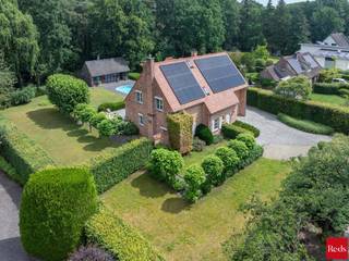 <p>Een charmante, energiezuinige villa met zwembad en indrukwekkend houten poolhouse in het groen van Zoersel</p>
<p>In een rustige, doodlopende straat in Zoersel, verscholen tussen het groen, bevindt zich deze bijzonder charmante woning die uitblinkt in ruimte, licht, comfort en privacy. Dankzij de uitstekende ligging geniet u hier van absolute rust en een groene omgeving, terwijl het centrum, scholen en alle voorzieningen vlot bereikbaar blijven.</p>
<p>Bij het betreden van de woning wordt u meteen omarmd door een warme en uitnodigende sfeer. Een lichte inkomhal met gastentoilet en vestiarekast verwelkomt u in deze charmante woning. De ruime leefruimtes genieten dankzij de grote raampartijen van een overvloed aan natuurlijk licht en staan in directe verbinding met de prachtig aangelegde tuin met zwembad en meerdere terrassen. De combinatie van hoogwaardige materialen, warme accenten en een doordachte indeling zorgt voor een bijzonder aangename woonbeleving.</p>
<p>De woonkamer vormt samen met de eetruimte het hart van de woning en beschikt over een sfeervolle gashaard, die zorgt voor extra warmte en gezelligheid tijdens de koudere maanden. De volledig ingerichte keuken sluit hier harmonieus op aan en biedt alle comfort voor dagelijks gebruik en gezellige momenten met familie en vrienden.</p>
<p>Een elegante houten trap met een prachtige vide leidt u naar de eerste verdieping waar de slaapkamers zich bevinden. De woning beschikt over een ruime mastersuite met een royale dressing en een stijlvolle badkamer, waardoor een echte privé-oase ontstaat. Daarnaast zijn er drie zeer ruime kinderkamers. Eén van deze kamers geniet dankzij de rechtstreekse verbinding met een volledig ingerichte zolderverdieping over een unieke extra ruimte, ingericht als een echte droomstudio voor elk kind. De kinderen beschikken bovendien over een aparte, ruime badkamer, uitgerust met een bad, inloopdouche, lavabo en toilet.</p>
<p>Verder beschikt de woning over een ruime waskamer, een praktische garage voor één wagen en een carport, waardoor ook op praktisch vlak aan alle comfort werd gedacht.</p>
<p>De zonnige, volwassen tuin met zwembad biedt volledige privacy en vormt de ideale setting voor lange zomeravonden, gezellige diners of ontspannen momenten met familie en vrienden.</p>
<p>Een absolute blikvanger van deze eigendom is het indrukwekkende houten poolhouse in de tuin. Dit stijlvolle bijgebouw vormt een volwaardige tweede leefruimte en is uitgerust met een gezellige zitruimte met kachel, een sfeervolle bar, een aparte bureauruimte, een sauna, douche en toilet. Hierdoor biedt het poolhouse een uitzonderlijke flexibiliteit: van ontspannings- en wellnessruimte tot volwaardige werk- of gastensuite. In combinatie met het zwembad, de zonnige terrassen en het omliggende groen ontstaat hier een unieke buitenbeleving met een permanent vakantiegevoel in eigen tuin.</p>
<p>Ook op vlak van energiezuinigheid scoort deze woning uitstekend dankzij de talrijke zonnepanelen, goed voor een gunstig EPC-label B, waardoor hedendaags comfort perfect gecombineerd wordt met duurzaam wonen.</p>
<p><strong>Bijzonderheden</strong></p>
<ul>
<li>Zee van ruimte en uitzonderlijke lichtinval</li>
<li>Prachtig aangelegde tuin met zwembad</li>
<li>Imposant houten poolhouse met wellness- en leeffaciliteiten</li>
<li>Energiezuinig wonen met EPC-label B</li>
<li>Aanzienlijke zonnepaneleninstallatie (PV)</li>
<li>Asbestvrij</li>
</ul>
<p>Kortom: een uitzonderlijk charmante en energiezuinige villa waar ruimte, licht, natuur en luxe buitenbeleving samenkomen. Een unieke thuis voor wie op zoek is naar rust, privacy en een hoogwaardige woonomgeving in het groene Zoersel.<br /><br />Voor meer informatie of bezoek aan deze gezellige woning neem contact met Sigalit via sigalit@reds.be of op 0475668474</p>