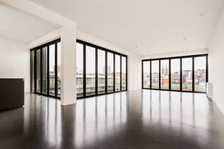 <p>Exclusieve loft met panoramisch uitzicht in de Theaterbuurt<br /><br />Wonen in een unieke loft, ontworpen door de gerenommeerde architect <strong>Vincent Van Duysen</strong>, op een toplocatie vlak bij de Botanische Tuin? Deze stijlvolle en uitzonderlijk ruime loft combineert tijdloze architectuur, hedendaags comfort en een bijzonder gevoel van ruimte en licht.<br /><br />Gelegen in de Theaterbuurt, bevindt u zich op wandelafstand van talrijke winkels, gezellige restaurants en andere voorzieningen. Het centrum ligt letterlijk aan uw voeten.<br /><br /><strong>Een loft met een uniek binnen-buitengevoel</strong><br /><br />Via de inkomhal betreedt u de ruime en <strong>lichtrijke leefruimte.</strong> Twee zijden van de leefruimte zijn voorzien van grote, volledig openklapbare ramen. Hierdoor vloeien interieur en terras naadloos in elkaar over en geniet u binnen van een heerlijk buitengevoel én een prachtig uitzicht over de daken van het stadscentrum.<br /><br />De<strong> open keuken met kookeiland </strong>is volledig uitgerust met de nodige toestellen en sluit rechtstreeks aan op het terras. Het ruime terras strekt zich uit over de volledige lengte van de keuken en leefruimte en vormt zo een ideale plek om te ontspannen of gasten te ontvangen.<br /><br /><strong>Twee slaapkamers, elk met eigen badkamer</strong><br /><br />De royale mastersuite omvat een ruime slaapkamer, een praktische dressing en een stijlvolle badkamer met wastafel, ligbad en toilet. De tweede slaapkamer beschikt eveneens over een eigen en-suite badkamer, uitgerust met een inloopdouche en wastafel.<br /><br />Verder beschikt de loft over een ruime berging in de hal, voorzien van aansluitingen voor wasmachine en droogkast, een vestiaire en een afzonderlijk gastentoilet met handenwasser.<br /><br />Extra troeven:<br />- Mogelijkheid tot het huren van <strong>autostaanplaats </strong>nr. 3 aan €120 per maand<br />- <strong>Inclusief kelderberging</strong><br />- Energiezuinige verwarming op gas<br />- Grote openklapbare ramen in HR-beglazing voor een uniek binnen-buitengevoel<br />- Strakke gietvloeren<br />- Mogelijkheid tot <strong>huren via een vennootschap</strong><br /><br />Een uitzonderlijke loft voor wie op zoek is naar architectuur, ruimte, comfort en een centrale topligging in één bijzonder geheel.</p>
