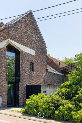 Gelegen op een prachtig perceel van ca. 55 are bevindt zich deze uitzonderlijke pastorijwoning met een authentiek en tijdloos karakter, harmonieus geïntegreerd in een idyllische groene omgeving met adembenemende vergezichten over het omliggende landschap. Deze unieke eigendom combineert charme, ruimte en privacy op een zeldzame manier en biedt een exclusieve woonbeleving voor wie op zoek is naar rust en natuur, zonder in te boeten aan comfort.<br /><br />De buitenruimte is zonder twijfel een absolute troef: een uitgestrekte weide creëert een gevoel van vrijheid. De weidse vergezichten over het omliggende groen, het natuurlijk gefilterd verwarmd zwembad en het grote overdekte terras maken van deze buitenruimte een oase van rust. <br /><br />Bij het betreden van de woning wordt u verwelkomd in de impressionante inkomhal met vestiaire, gastentoilet en de centrale betonnen trap als absolute eyecatcher. De lichtrijke leefruimte vormt het hart van de woning en biedt een gezellige zit- en eethoek met openhaard, aansluitend op de volledig uitgeruste keuken. In de kelder vindt u een wasplaats, een technische ruimte en een ruime opbergkelder. De eerste verdieping beschikt over drie volwaardige kinderkamers en een douchekamer. De volledige tweede verdieping is voorbehouden voor de master suite, bestaande uit een royale slaapkamer met ensuite badkamer en dressing. <br /><br />De aanwezige schuren bieden bovendien een uitzonderlijk potentieel voor wie op zoek is naar extra uitbereidingsmogelijkheden.
