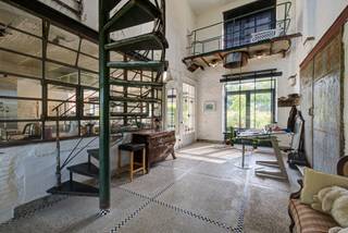 Op een exclusief privédomein met slechts 10 woningen, volledig omgeven door een slotgracht, bevindt zich deze bijzondere loftwoning. Het domein geniet van een ongeëvenaarde ligging met weidse zichten over een beschermd natuurgebied en een indrukwekkende vijver van meer dan 6 hectare.<br />Via een statige kasteelpoort met toegangscontrole betreedt u het domein. Een sfeervolle dreef en charmante brug leiden naar een binnenplein met bijkomende parkeergelegenheid, waar deze authentieke en karaktervolle woning zich bevindt. De loft onderscheidt zich door haar royale volumes, unieke afwerking en grote stalen raampartijen die zorgen voor een uitzonderlijke lichtinval. Achteraan openen de ramen naar een privatieve tuin met terras en zicht op de slotgracht. Op de eerste verdieping bevindt zich bovendien een riant zonneterras met een adembenemend panorama over de omliggende natuur tussen de Nete en het Netekanaal. <br />Met een bewoonbare oppervlakte van maar liefst 352 m² omvat de woning onder meer: inkomhal met gastentoilet, volledig uitgeruste keuken met ontbijthoek, wasplaats, ruime eet- en leefruimte, bureau, atelier, dubbele garage. Op de verdiepingen bevinden zich: vide en bibliotheek, sfeervol salon met toegang tot het panoramische terras, 3 slaapkamers, dressing, 2 badkamers en zolderruimte.<br />Het atelier en de dubbele garage bieden bovendien diverse mogelijkheden voor hobby, werk of opslag.<br />Als bewoner geniet u mee van de uitzonderlijke troeven van het domein. De grote vijver leent zich perfect voor zwemmen, varen en vissen. Daarnaast zijn er een boothuis met aanlegsteiger en een petanquebaan aanwezig. Bent u op zoek naar een woning met karakter, privacy en een permanent vakantiegevoel, midden in een unieke natuurlijke omgeving? Dan is dit een buitenkans. De verhuurder biedt enkel een jaarcontract aan dat eventueel verlengbaar is. De woning kan bemeubeld gehuurd worden. Gemeenschappelijke kost bedraagt extra 150 euro/maand.