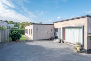 <p><strong>Vrijstaande bungalowvilla met 4 slaapkamers en prachtig uitzicht in Asse</strong></p>
<p>Deze laagbouw-villa in typische sixties-stijl is discreet gelegen op een mooi rechthoekig perceel van 22a 20ca, nabij centrum Asse en invalswegen richting Brussel en het binnenland. Dankzij de lichte helling van het terrein geniet de woning een uitzonderlijk verzicht op de groene omgeving.</p>
<p>De woning wordt betreden via een ruime, centrale inkomhal die toegang biedt tot de lichtrijke leefruimte met open haard en eetplaats. Het grote schuifraam met hoogrendementsglas in aluminium geeft uit op het zonnige terras en de tuin met prachtig uitzicht.</p>
<p>Aansluitend bevindt zich de halfopen keuken die modernisering vraagt, en een nachthall die toegang geeft tot 4 volwaardige slaapkamers, een bureel, badkamer met ligbad, wastafel en toilet, en een praktische bergruimte.</p>
<p>De woning beschikt verder over meerdere kelders en een inpandige garage. Recent werd de eigendom voorzien van een lucht-lucht warmtepomp en 14 zonnepanelen, wat zorgt voor energiezuiniger comfort.</p>
<p>Mits esthetische opfrissing heeft deze bungalow alles in huis om uit te groeien tot een unieke gezinswoning of karaktervolle villa in een bijzonder groene en rustige zone rond Asse, met zwembad!</p>
<p>Plan jouw bezoek via rune.stallaert@living-stone.be of telefonisch via 02 466 05 75</p>