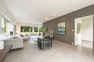 GELIJKVLOERSInkomhal 13m² op tegel met gastentoilet en handenwasser.Bureel 10m² op parket met kastenwand.Woonkamer 40m² op tegel met vast tv-meubel...