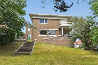 Deze woning is een beschermde, historische kustvilla gelegen in de prestigieuze villawijk De Concessie, een uniek en beschermd dorpsgezicht dat bekendstaat om zijn uitzonderlijke erfgoedwaarde en karaktervolle architectuur.<br /><br />Deze charmante villa uit 1933 bevindt zich op een toplocatie, op wandelafstand van het strand en het centrum van De Haan. Gelegen op een perceel van ca. 780 m² combineert deze eigendom authentieke charme, ruime volumes en een uitzonderlijk potentieel.<br /><br />Bij het binnenkomen wordt u verwelkomd in een statige inkomhal met authentieke tegelvloer en karaktervolle houten trap. De gezellige leefruimte ademt sfeer dankzij de originele vloeren, schouw en grote raampartijen die zorgen voor een aangename lichtinval. Aansluitend bevindt zich de keuken met toegang tot de tuin en de kelderverdieping. <br /><br />De eerste verdieping telt vier slaapkamers, waarvan meerdere voorzien zijn van een lavabo en ingemaakte kasten. De badkamer beschikt over een ligbad, lavabo en toilet. Via de tussenverdieping bereikt u een afgesloten veranda/dakterras met zicht op het groen.<br /><br />De ruime kelderverdieping omvat een garage, technische ruimte, berging, sanitaire ruimte met douche en diverse opslagmogelijkheden.<br /><br />Buiten geniet u van een prachtige, groene tuin met meerdere terrasplaatsen, volwassen bomen en een optimale privacy. <br /><br />Centrale verwarming op aardgas aanwezig. EPC: 590 kWh/m² jaar (label F). <br /><br />Een zeldzame opportuniteit om eigenaar te worden van een karaktervolle historische villa in één van de meest gegeerde en beschermde wijken van de Belgische kust.