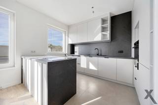 Welkom in de Raf Verhulstlaan 36-38, waar Immotrix met trots twee nieuw gerenoveerde appartementen op de eerste verdieping (ca. 100 m²) presenteert. Dit project overstijgt de standaard renovatie; het betreft een compromisloze, totale heropbouw met diep respect voor esthetiek, duurzaamheid en technische perfectie.
Vanaf de fundering tot de afwerking is werkelijk alles vernieuwd. Alle leidingen en de volledige elektriciteit zijn up-to-date en conform de strengste normen geplaatst. Dankzij een doorgedreven, hoogwaardige isolatiestrategie genieten deze appartementen van een zeldzaam en toekomstgericht EPC A-label — uw garantie op een zorgeloze en energiezuinige toekomst.
Bij het betreden van het appartement valt direct de indrukwekkende lichtinval op. De royale raampartijen aan de voorzijde laten het daglicht vloeiend weerspiegelen op de strakke vloerafwerking. De leefruimte loopt naadloos over in een hypermoderne leefkeuken. Deze blikvanger is uitgerust met een monumentaal kookeiland in een verfijnde, donkere natuursteenlook en afgewerkt met greeploze, gelaagde witte fronten en premium matzwarte kranen en details.
De badkamer ademt de sfeer van een high-end boetiekhotel. Dankzij de warme tonen het design-maatwerk, kamerhoge keramische tegels in een zachte zandkleur en een luxueuze inloopdouche met een minimalistische glazen wand, geniet u hier dagelijks van puur wellnesscomfort.
Het nachtgedeelte is doordacht ingedeeld en beschikt over twee volwaardige, rustgevende slaapkamers waarvan 1 met toegang naar het zonovergoten terras. Daarnaast herbergen deze appartementen een architecturaal geheim: een ruime, multifunctionele flex-room. Hoewel deze kamer bewust zonder buitenraam is ontworpen om een intieme en serene sfeer te waarborgen, biedt de ruimte een ongeziene flexibiliteit. Door de perfecte visuele en akoestische afzondering leent deze kamer zich uitstekend als een exclusieve walk-in dressing, een inspirerende en stille thuiswerkplek (home office), of een geborgen, fluisterstille babykamer. Een appartement op de 1ste verdieping is momenteel verhuurd aan 1.190 € per maand wat dit object ook tot een interessante investeringsopportuniteit maakt.
Wonen in Wommelgem betekent hier: intrekken zonder toegevingen, omringd door tijdloze esthetiek, modern comfort en een ongeëvenaard afwerkingsniveau. Een unieke kans voor wie op zoek is naar een instapklaar, turn-key droomappartement op een strategische locatie. Contacteer Immotrix voor uw exclusieve bezichtiging.