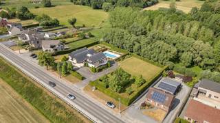 <p>Voor meer info of een bezoek, bel 054 69 39 37 – Deze <strong>indrukwekkende villa </strong>combineert elegante architectuur met een uitzonderlijke ligging nabij alle voorzieningen. Met een bruikbare vloeroppervlakte van 747 m² biedt deze eigendom alles voor wie op zoek is naar luxe, ruimte en comfort op een <strong>absolute toplocatie</strong>.</p>
<p>Bij het betreden van de woning wordt u verwelkomd in een royale inkomhal met praktische dressing. De lichtrijke woonkamer, dankzij de grote raampartijen, biedt een prachtig zicht op de <strong>perfect onderhouden tuin</strong>. In de wintermaanden zorgt de open haard voor extra sfeer en gezelligheid. Aansluitend bevindt zich de elegante eetkamer, ideaal voor gezellige diners en het ontvangen van gasten.</p>
<p>De volledig uitgeruste keuken sluit naadloos aan op het ruime <strong>zonneterras</strong>, vanwaar u een adembenemend uitzicht heeft op het <strong>zwembad </strong>en het achterliggende groen. Hier geniet u dagelijks van rust en privacy.</p>
<p>De villa beschikt over meerdere ruime slaapkamers, waarbij de master bedroom is voorzien van een <strong>eigen luxe badkamer en ruime dressing</strong>. Op de verdieping vindt u bovendien een grote zitruimte met mezzanine, een polyvalente opslagruimte en een ruime, gemakkelijk toegankelijke zolderkamer.</p>
<p>Als extra troef is de woning <strong>volledig onderkelderd</strong>. Hier bevindt zich een zeer ruime garage met plaats voor maar liefst<strong> 6 à 7 wagens</strong>, een praktische kitchenette, een douchecabine en verschillende opslagmogelijkheden. Deze ruimte biedt tal van mogelijkheden voor hobby's, opslag of extra comfort.</p>