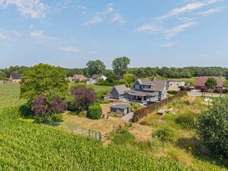 Deze charmante en goed onderhouden woning is gelegen langs de verbindingsweg tussen Mol en Meerhout, op een prachtig perceel van ca. 2.407 m². Dankzij de ruime indeling, de vele mogelijkheden en de mooie tuin met uitzicht op de achterliggende velden, biedt deze woning alle comfort voor wie op zoek is naar ruimte<br /><br />Gelijkvloers:<br />Via de inkomhal komt u terecht in de bijzonder ruime en lichtrijke woonkamer. De leefruimte bestaat uit een gezellige zithoek met haard en een ruime eetkamer. Aansluitend bevindt zich de volledig uitgeruste keuken met ontbijthoek, waar u geniet van een aangenaam zicht op de tuin. Verder beschikt het gelijkvloers over een praktische bijkeuken/wasplaats.<br /><br />Daarnaast is er een volwaardige tweede leefruimte aanwezig, die diverse mogelijkheden biedt en perfect kan dienen voor een vrij beroep, praktijkruimte of kantoor aan huis. Verder vindt u nog een afzonderlijke bureauruimte, een gastentoilet en een inpandige garage.<br /><br />Verdieping:<br />Op de bovenverdieping bevinden zich drie ruime slaapkamers. De badkamer is uitgerust met een inloopdouche, een enkele wastafel en een toilet.<br /><br />Buitenruimte:<br />De aangelegde tuin vormt een heerlijke plek om tot rust te komen en in alle privacy van het buitenleven te genieten. Bovendien biedt de tuin een prachtig, vrij uitzicht over de achterliggende velden, wat bijdraagt aan het landelijke karakter van deze eigendom.<br /><br />Verder beschikt de woning over een praktische kelder.<br /><br />Bijzonderheden:<br />* EK conform<br />* Inpandige garage<br />* Tweede leefruimte geschikt voor beroepsdoeleinden of praktijk aan huis<br />* Prachtig uitzicht op achterliggende velden