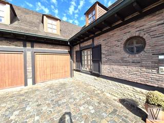 Centraal gelegen ruime verzorgde villa op 737 m², bestaande uit de inkomhal met toilet, (slaap)kamer/polyvalente ruimte,  woon/leefruimte (alle met inbouwspots) met aansluitend de nieuwe keuken, zonnige veranda, berging/wasruimte en 2de toilet, dubbele garage, tuin met terras en bijgebouw met sauna en douche.. Op het verdiep zijn er maar liefst 5 slaapkamers telkens met inbouwkasten en lavabo. Zolder. Houten ramen met dubbel glas. De woning is ingericht met kwalitatieve materialen. Open haard. Kelder. Zonnepanelen. Er is plaats voor 4 auto's op de oprit.