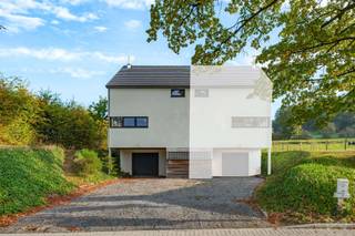 We Invest Malmedy presenteert u deze woning met drie gevels in Chôdes, op de heuvels boven Malmedy, in een groene omgeving en toch dicht bij alle voorzieningen. De woning is gebouwd in 2007, verkeert in goede algemene staat en is direct bewoonbaar, zonder dat er ingrijpende renovaties nodig zijn.<br /><br />De begane grond bestaat uit: een garage met ruimte voor één auto en veel opbergruimte. Op de eerste verdieping: een hal met apart toilet, een ruime woon- en eetkamer met een houtkachel, een gedeeltelijk ingerichte keuken en een wasruimte met plaats voor de wasmachines. Op de tweede verdieping: twee grote slaapkamers, een mezzanine die ideaal is om in te richten als kantoor, en een badkamer met een bad en een douche.<br />Buiten beschikt het huis over een aangename, omheinde tuin met terras, evenals meerdere parkeerplaatsen aan de voorzijde. De weg voor het huis is onlangs gerenoveerd en is nu voorzien van een verkeersdrempel en een fietspad.<br /><br />Technisch gezien is het pand voorzien van PVC-kozijnen met dubbele beglazing, elektrische accumulatorverwarming, een houtkachel, gecontroleerde mechanische ventilatie (VMC) en een gezamenlijk microzuiveringsstation met het naburige huis. De elektrische installatie voldoet aan de voorschriften en de EPC-klasse is C (ref. 20250522001226 – specifiek verbruik: 231 kWh/m²/jaar – totaal verbruik: 29.145 kWh/jaar).<br /><br />Een ideale, functionele woning om te genieten van een aangename woonomgeving in de buurt van Malmedy. Wilt u een bezichtiging? Bel Amandine op 0499/66.71.45