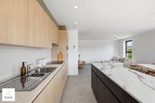 <strong>Exclusief en energiezuinig nieuwbouwappartement met ruim terras</strong><br /><br />Ontdek dit stijlvolle en hoogwaardig afgewerkte appartement op de eerste verdieping van een kleinschalige residentie met slechts zes appartementen. Dankzij de moderne architectuur, kwalitatieve materialen en doordachte indeling geniet u hier van een unieke combinatie van comfort, energiezuinigheid en een rustige ligging.<br /><br />Het appartement verwelkomt u in een lichtrijke en ruime leefruimte met grote raampartijen die zorgen voor een overvloed aan natuurlijk licht. De open, volledig geïntegreerde keuken vormt het hart van de woning en sluit naadloos aan op het royale, overdekte terras, waar u in alle rust kunt genieten van het buitenleven.<br /><br />Verder beschikt het appartement over twee volwaardige slaapkamers, een stijlvolle badkamer en een apart gastentoilet. Dankzij de vloerverwarming in alle ruimtes, de energiezuinige warmtepomp en zes individuele zonepanelen geniet u het hele jaar door van een aangenaam binnenklimaat met een optimaal energieverbruik.<br /><br />De residentie is uitgerust met een lift die u rechtstreeks toegang biedt tot de ondergrondse parkeergarage. Bij het appartement is de aankoop van twee ondergrondse autostaanplaatsen verplicht, deze zijn inbegrepen in de prijs.<br /><br />Troeven:
<ul>
<li>Kleinschalige residentie met slechts 6 appartementen</li>
<li>Moderne en tijdloze architectuur</li>
<li>Ruime en lichtrijke leefruimte met open keuken</li>
<li>2 volwaardige slaapkamers</li>
<li>Stijlvolle badkamer en apart gastentoilet</li>
<li>Royaal overdekt terras</li>
<li>Grote raampartijen</li>
<li>Vloerverwarming in het volledige appartement</li>
<li>Warmtepomp en 6 individuele zonepanelen</li>
<li>Lift aanwezig</li>
<li>Rustige ligging op wandelafstand van het centrum</li>
<li>Onmiddellijk beschikbaar</li>
<li> </li>
</ul>
Bent u op zoek naar een instapklaar appartement waar hedendaags wooncomfort, energiezuinigheid en een uitstekende ligging perfect samenkomen? Dan is dit exclusieve appartement zonder twijfel een bezoek waard.<br />Wenst uw graag een bezoek ter plaatse? Aarzel niet om contact op te nemen info@lotemvastgoed.be<br /><span>Ook uw eigendom verkopen? Contacteer ons vrijblijvend op info@lotemvastgoed.be </span><br /><br />
