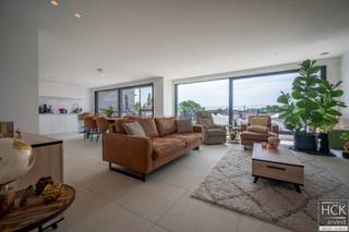 <strong>De ligging</strong><br />Deze <strong>luxueuze penthouse</strong> is gelegen op de tweede verdieping van residentie "Kruisem 47", nabij het centrum van Kruishoutem en midden in een groene omgeving. De stijlvolle residentie, opgeleverd in 2022, voldoet aan de BEN-normen (<strong>Bijna Energie Neutraal</strong>) dankzij het e-peil van E23, en EPC waarde van amper 41 kWh/m² jaar.<br />Het appartement is goed voor een bewoonbare oppervlakte van maar liefst <strong><span>109m</span>² </strong>en bevat een groot zuidgeoriënteerd terras van <span><strong>30 m²</strong> (toegankelijk via de woonkamer/keuken). D</span>ankzij de <strong>grote raampartijen, hoge plafonds en kamerhoge deuren</strong> bezorgt dit appartement u een uiterst <strong>aangenaam </strong>en <strong>lichtrijk </strong>gevoel.<br /><br /><strong>De indeling</strong><br />Inkomhal - apart gastentoilet - ruim & lichtrijke woonkamer met <strong>geautomatiseerde screens aan de ramen</strong> (met afstandsbediening) - moderne keuken met <strong>keukeneiland </strong>voorzien van dubbele spoelbak en aanzitplaatsen, uitschuifbare laden en uitschuifbare voorraadkast, inductiekookplaat, grote frigo met diepvriesvak, combi-oven, vaatwasser en dampkap (keukenblad in witte composiet) - aanpalend <strong>zuidgeoriënteerd terras</strong> voorzien van een vorstvrije kraan - berging met aansluiting voor wasmachine/droogkast, uitgietbak en waterontharder - 2 slaapkamers <span>met<strong> parket vloeren</strong> </span>en badkamer voorzien van dubbele wastafel en inloopdouche. Tevens is er een <strong>ruime garagebox inbegrepen in de huurprijs </strong>alsook een handige <strong>bergkast aan de inkomhal</strong>.<br /><br /><strong>Kenmerken</strong><br />- BEN-appartement!! EPC: 41 kWh/m² jaar - A-label<br />- CV via aardgas<br />- Luxueuze afwerking: geautomatiseerde screens, design radiatoren, dimbare inbouwspots met 'Living Now' schakelaars.. (m.a.w. een <strong>topafwerking</strong>!!).<br /> <br /><strong>Troeven</strong><br />- uiterst ruim en luxueus appartement!!<br />- <strong>zuidgericht terras met zicht op groen!!</strong><br />- zeer energiezuinig!! <br />- topafwerking!!<br /> <br />Een lift is aanwezig in het gebouw.<br /><br />Beschikbaarheid: <span>01/01/2027</span><br /> <br />Gemeen. kosten: € 60.00<br /> <br />Voor meer informatie of een bezoek reageer via het contactformulier of stuur naar info@hckinvest.be