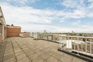 <p><span>Penthouse-appartement met panoramische terrassen en uitzonderlijke lichtinval</span></p><p><span>Op de zevende en hoogste verdieping van een verzorgd gebouw bevindt zich dit ruime penthouse-appartement van ca. 140 m², omringd door twee royale zonneterrassen met een gezamenlijke oppervlakte van circa 100 m². Dankzij de unieke ligging geniet u hier van een prachtig open uitzicht over de groene omgeving van het Rivierenhof aan de voorzijde en een weids stadszicht aan de achterzijde.</span></p><p><span>Een bijzonder pluspunt is dat de lift rechtstreeks toegang biedt tot het appartement, wat zorgt voor extra comfort en privacy.</span></p><p><span>Bij het betreden van het appartement komt u binnen in een ruime inkomhal die toegang geeft tot de leefruimte. De lichtrijke woonkamer vormt het hart van de woning en biedt dankzij de grote raampartijen een aangename connectie met de buitenruimtes. De sfeervolle houtkachel draagt bij aan een warme en gezellige woonbeleving.</span></p><p><span>Aansluitend bevindt zich de functionele keuken met voldoende kastruimte en werkoppervlak. Vanuit de leefruimte heeft u directe toegang tot de terrassen, waardoor binnen en buiten naadloos in elkaar overvloeien.</span></p><p><span>Het appartement beschikt over drie volwaardige slaapkamers, ideaal voor gezinnen, thuiswerkers of wie extra ruimte wenst. De badkamer is uitgerust met zowel een ligbad als een douche en een dubbele wastafel. Daarnaast is er een afzonderlijk gastentoilet en een praktische berging met aansluiting voor wasmachine en droogkast.</span></p><p><span>Voor extra comfort werd het appartement voorzien van elektrische rolluiken, een veiligheidsdeur, videofoon, veiligheidsglas en een alarmsysteem.</span></p><p><span>Een garage kan afzonderlijk worden aangekocht of gehuurd worden.</span></p><p><span>Troeven:</span></p><ul><li><span>Penthouse op de hoogste verdieping </span></li><li><span>Ca. 140 m² bewoonbare oppervlakte </span></li><li><span>Twee ruime terrassen van samen ca. 100 m² </span></li><li><span>Lift met directe toegang tot het appartement </span></li><li><span>Open en lichtrijke leefruimte </span></li><li><span>Uitzicht op het Rivierenhof en de omgeving </span></li><li><span>Elektrische rolluiken en uitgebreide veiligheidsvoorzieningen </span></li><li><span>Mogelijkheid tot aankoop of huur van een garage </span></li></ul><p><span>Een unieke woonkans voor wie op zoek is naar ruimte, privacy, buitenleven en een panoramisch uitzicht op een uitstekende locatie.</span></p>