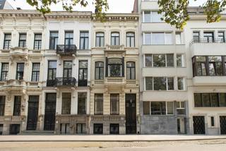 Bekijk alvast de videotour, het EPC, conform EK, grondplannen, asbestinventaris,..... via de Wellimmo-site ('documenten')<br /><br />In het hart van het Antwerpse Zuid, op een absolute toplocatie aan de prestigieuze Amerikalei, bevindt zich deze luxueus gerenoveerde neoclassicistische herenwoning uit 1890, naar architect JB De Pooter. Het pand onderging een hoogwaardige renovatie met respect voor zijn historische karakter. Prachtige authentieke elementen, waaronder de originele parketvloeren, sierlijsten, moulures en verfijnde wanddecoraties, bleven zorgvuldig bewaard en werden harmonieus gecombineerd met hedendaags wooncomfort. Achter de statige gevel schuilt een uitzonderlijk eigendom met een totale bruikbare oppervlakte van circa 335 m², inclusief het souterrain. De woning staat via een interne doorgang rechtstreeks in verbinding met het achterliggende perceel aan de Brederodestraat. Hier bevindt zich een ruime garage voor twee wagens, voorzien van een automatische garagepoort — een zeldzame en bijzonder waardevolle troef in de stad. Beide percelen beslaan samen een totale grondoppervlakte van 140 m².<br />Het pand is momenteel volledig ingericht als een luxueus guesthouse met vier ruime en instapklare suites. Elke suite beschikt over een eigen badkamer met toilet. De gelijkvloerse verdieping is thans ingericht als gezamenlijke leef en eetruimte en voorzien van een prachtig ingerichte keuken.  De woning telt wel zes toiletten, waarvan er 2 zich in de gemeenschappelijke delen bevinden.<br /><br />Voor de uitbating als guesthouse werd een vergunning afgeleverd door Toerisme Vlaanderen en het pand voldoet aan de geldende brandveiligheidsvoorschriften. Het guesthouse kan desgewenst meteen worden voortgezet. Ook de overname van het aanwezige meubilair is bespreekbaar, waardoor een bijzonder vlotte voortzetting van de huidige activiteit mogelijk is.<br />Dankzij de flexibele indeling biedt het eigendom echter nog tal van andere mogelijkheden. De suites kunnen worden ingericht als bijkomende slaapkamers, bureaus of polyvalente ruimtes. Zo leent het pand zich eveneens uitstekend als volwaardige herenwoning, als combinatie van wonen en werken, of voor gedeeltelijke dan wel volledige verhuur.<br /><br />Op de eerste verdieping bevindt zich een prachtige en lichtrijke leefruimte met volledig ingerichte keuken. In het souterrain werd de vierde suite ondergebracht en is bovendien een aangename wellnessruimte ingericht.<br />Ook de buitenruimtes zijn uitzonderlijk voor deze centrale ligging. Boven op de garage aan de Brederodestraat ligt een royaal en zonnig dakterras van circa 64 m². Hogerop in de woning bevindt zich nog een tweede terras.<br />Ook technisch is het eigendom volledig op punt: de elektrische installatie is conform, het pand werd asbestveilig gekeurd en beschikt over een EPC-label C.<br /><br />Kortom: Een karaktervol en hoogwaardig gerenoveerd eigendom waarin historische grandeur, authentieke details en hedendaags comfort harmonieus samenkomen. Dankzij de vergunde uitbating, de royale oppervlaktes, de dubbele garage en de bijzonder veelzijdige indeling is dit een pand met werkelijk uitzonderlijke mogelijkheden, gelegen op een van de meest gegeerde locaties van Antwerpen.<br />Een karaktervolle parel op toplocatie die niet gauw op de Antwerpse vastgoedmarkt verschijnt!<br /><br />Voor meer info en uw bezoek bel 03.225.00.68 of info@wellimmo.net <br /> 
