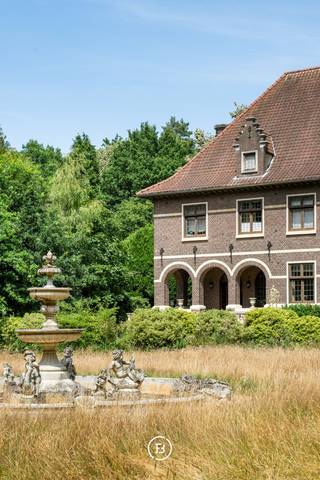 In de Zilverkust van Lanaken ligt dit karaktervolle landgoed, verscholen op een groen en bebost domein van circa 2,5 hectare. Het landhuis dateert uit het interbellum en heeft een vloeroppervlakte van 996 m².<br /> <br />Het landhuis telt veel grote ruimtes, verspreid over het gelijkvloers en de twee verdiepingen. Daardoor zijn er heel wat mogelijkheden om de indeling aan te passen aan het toekomstige gebruik. Ook de kelder biedt veel plaats voor opslag en technische voorzieningen.<br /><br />Verschillende oorspronkelijke elementen bleven behouden, waaronder rode tegelvloeren, houten vloeren en parket, balkenplafonds, lambriseringen, ingebouwde kasten, glas-in-loodramen en verschillende schouwen. De grote ramen bieden zicht op het omliggende groen.<br /><br />Aan de woning liggen verschillende terrassen en een omsloten binnenplaats met fontein, rondbogen en een toren. Verder omvat het domein verschillende bijgebouwen.<br /><br />De ligging in de Zilverkust combineert rust, privacy en een groene omgeving met een vlotte verbinding naar Maastricht en de omliggende regio.