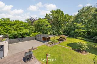 Voor meer info en foto’s, surf naar www.swevers.be – !! Via de 3D Tour Matterport kan u virtueel door het pand wandelen !! Deze instapklare open bebouwing in Diepenbeek combineert wonen en werken op een slimme manier. De woning uit 2010 is uitstekend onderhouden en telt 178 m² bewoonbare oppervlakte, aangevuld met een commerciële ruimte van 105 m² – ideaal voor zelfstandigen of vrije beroepen. De handelsruimte is gescheiden van het privé-gedeelte en voorzien van flexibele opzegmogelijkheden. Binnen geniet u van een ruime leefruimte (50 m²), een volledig uitgeruste keuken (15 m²), drie volwaardige slaapkamers – waarvan één met dressing – en een moderne badkamer. Extra troef: het riante dakterras van ca. 90 m² met jacuzzi. De zolder van 50 m² biedt uitbreidingsmogelijkheden. De kelderverdieping van 174 m² biedt ruime opbergmogelijkheden. Comfort is verzekerd met vloerverwarming, warmtepomp, zonnepanelen (EPC-label A), alarminstallatie en camerabewaking. Buiten geniet u van een zuidgerichte tuin met groen uitzicht en voldoende parkeergelegenheid dankzij een carport en inpandige garage van elk 25 m². U profiteert hier van een uiterst gunstige ligging met alle benodigde voorzieningen binnen handbereik. Voor meer informatie, bel 011 255 155. Bron bewoonbare oppervlakte: EPC – verslag.
