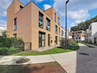 <p><span>In de recente woonwijk Hof van Gent bevindt zich deze instapklare BEN-woning, opgeleverd in 2023. Dankzij de hoogwaardige afwerking en de zorgvuldig gekozen materialen geniet u hier van een woning waar comfort, kwaliteit en duurzaamheid perfect samengaan. Het BEN-label garandeert bovendien een bijzonder laag energieverbruik en een beperkte energiefactuur.</span></p><p><span>Hof van Gent biedt het beste van twee werelden: rustig wonen in een groene omgeving én alle voordelen van de stad binnen handbereik. De Leebeek vormt een natuurlijke grens rond de wijk en creëert een aangenaam en groen woonkader. Tegelijk geniet u van een uitstekende bereikbaarheid via de E40, E17, R4 en N60. Bus- en tramhaltes bevinden zich op wandelafstand en het station Gent-Sint-Pieters ligt op slechts 2,5 km. Ook scholen, supermarkten, het UZ Gent en tal van andere voorzieningen bevinden zich in de onmiddellijke omgeving.</span></p><p><span>Bij het betreden van de woning komt u terecht in een ruime inkomhal met apart gastentoilet. De lichtrijke leefruimte vormt samen met de volledig geïnstalleerde open keuken het hart van de woning. Dankzij de grote raampartijen loopt het binnen- en buitenleven naadloos in elkaar over en geniet u van een aangenaam zicht op de gezellige tuin met terras. Op het gelijkvloers bevinden zich bovendien twee praktische bergingen.</span></p><p><span>De eerste verdieping omvat drie slaapkamers, een badkamer met ligbad en dubbele wastafel, een apart toilet en een handige wasberging met aansluitingen voor wasmachine en droogkast. De ingebouwde boekenkast blijft aanwezig en vormt een stijlvolle en functionele meerwaarde. Op de tweede verdieping bevindt zich een ruime vierde slaapkamer met een tweede badkamer, uitgerust met een douche en wastafel.</span></p><p><span>Ook op technisch vlak is deze woning bijzonder goed uitgerust. Zo zorgen de acht zonnepanelen, de regenwaterput van 5.000 liter (aangesloten op het gelijkvloerse toilet, de wasmachine en het buitenkraantje) en de septische put van 2.000 liter voor een efficiënte woonervaring. Daarnaast zijn alle vijf de zuidgerichte ramen voorzien van zonnescreens, terwijl vliegenramen aanwezig zijn aan elk raam. Verder werd overal plafondverlichting geïnstalleerd en zijn alle ruimtes reeds uitgerust met gordijnrails. Ten slotte is er een gemeenschappelijke fietsenberging waar u 2 fietsen kan plaatsen.</span></p><p><span>Een extra troef is de gezellige buurtsfeer. Hof van Gent staat bekend als een kindvriendelijke woonomgeving waar kinderen veilig kunnen spelen en buren elkaar kennen. Het warme buurtgevoel en de aangename sociale contacten maken van deze wijk een ideale plek voor gezinnen.</span></p><p><span>Kortom, deze recente en uitstekend onderhouden BEN-woning combineert ruimte, energiezuinigheid, wooncomfort en een topligging in een groene en kindvriendelijke omgeving dichtbij het centrum van Gent.</span></p><p><span> </span></p><p><span>De woning is beschikbaar vanaf 01/12/2026. Domicilie verplicht. Huurovereenkomst van 1 jaar met mogelijkheid tot verlenging. Geen gemeenschappelijke kosten. </span></p><p><span> </span></p>
