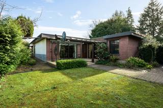 Deze uiterst charmante halfopen woning met bijgebouw is gelegen in een groene en rustige omgeving, vlakbij de vaart en de E10-plas, een ideale locatie voor fiets- en wandelliefhebbers.<br /><br /><strong>Indeling hoofdwoning</strong><br />Via de verzorgde voortuin betreedt u de woning in de inkomhal. De gezellige woonkamer met eetruimte vormt het hart van het huis. Aansluitend bevindt zich de ruime keuken. Achteraan is er een polyvalente ruimte die kan ingericht worden als bureau, speelkamer of extra zithoek. Vanuit de keuken, eetkamer én polyvalente ruimte heeft u directe toegang tot de tuin.<br />Op de eerste verdieping bevinden zich momenteel twee ruime slaapkamers (voorheen drie, eenvoudig terug te brengen naar de oorspronkelijke indeling) en een badkamer uitgerust met ligbad, lavabomeubel, toilet en aansluiting voor wasmachine en droogkast.<br />Verder beschikt de woning over een praktische zolderruimte.<br /><br /><strong>Bijgebouw</strong><br />Achteraan het perceel bevindt zich een bijgebouw.<br /><br /><strong>Tuin en extra’s</strong><br />De prachtig aangelegde tuin met vijver en verschillende zithoeken biedt een oase van rust en privacy.<br />Daarnaast is er een ruime garage met opbergzolder, evenals een kelder en kruipruimte onder de hoofdwoning.<br /><br /><strong>Bijzonderheden:</strong><br />+ EPC: C – 285 kWh/m²<br />+ Groene, rustige omgeving<br />+ Nabij vaart en E10-plas