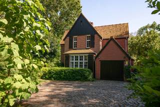 Charmante cottagevilla ' De Zandloper' gelegen op een unieke locatie nabij de Kalmthoutse Heide. De woning straalt één en al authenticiteit en charme uit en is zeer rustig gelegen aan het einde van een doodlopende straat.<br /><br />De villa werd gebouwd begin jaren '1900 en er werd aangebouwd in de jaren '80.<br /><br />We betreden de woning in de inkomhal met vestiaire en gastentoilet. Naast de inkom vinden we een gelijkvloers slaapkamer of bureau / praktijkruimte met authentieke schouw. Verder komen we in een L-vormige leefruimte in meerdere niveaus met zitruimte en eetkamer / speelkamer. De originele ornamenten, moulures en wandtegels zijn mooi bewaard gebleven. De leefruimte beschikt over een vernieuwde houtkachel. Aansluitend vinden we de ingerichte keuken met authentieke tegels en een wasplaats / bijkeuken. Achteraan vinden we een overdekt terras.<br /><br />Ten slotte vinden we op het gelijkvloers een bijkeuken/wasplaats met zijingang en een garage met plaats voor één wagen.<br /><br />De authentieke trap leidt naar de eerste verdieping die toegang geeft tot drie slaapkamers, een bureauruimte en twee badkamers. Eén slaapkamer beschikt over een eigen overdekt terras.<br /><br />De zolderverdieping heeft een zolderkamer en een berging.<br /><br />De villa is gebouwd op een prachtig, privatief perceel met een mooie aangelegde tuin. Op de oprit is er voldoende parkeerplek met plaats voor vier wagens. <br /><br />De woning beschikt over een vergunning als vakantiewoning, wat uniek is in deze omgeving.<br /><br />Permanente bewoning is uiteraard ook mogelijk.<br /><br />Een uniek object in Kalmthout!<br /><br />De villa is gelegen aan het einde van een doodlopende straat in een kindvriendelijke buurt 'Heuvel' vlakbij de Kalmthoutse Heide. Een bijzondere locatie in de natuur, maar vlakbij de centra van Heide en Kalmthout. Alle voorzieningen zoals winkels, scholen en openbaar vervoer bevinden zich op nabije afstand.<br /><br />De oprit van de autosnelweg is vlot bereikbaar met een goede verbinding naar Antwerpen en Nederland.