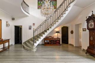 Domein "Ter Varenbeuke" is gelegen in het Turnhouts Vennengebied tussen Turnhout en Baarle-Hertog en omvat een schitterend landhuis met bijgebouwen (voormalige blekerij Borghs), omgeven door een groene mix van park, weilanden, bos en vijverpartij. Dit alles op ruim 12 ha met de mogelijkheid nog extra grond aan te kopen. <br /><br />De lange oprijlaan vanaf de straatzijde brengt u naar de hoofdvilla, dewelke centraal is gesitueerd op het eigendom. We betreden dit landhuis via de centrale inkomhal op Portugese marmer dewelke links voorzien is van een vestiaire met gastentoilet en anderzijds uitgeeft op de majestueuze trappenhal. Rechts van de inkomhal betreden we de woonkamer georiënteerd op het zuiden dewelke heel de dag van veel natuurlijke lichtinval geniet. De grote eetkamer met uitzicht over het park en de vijver is bereikbaar via de woonkamer en de trappenhal.<br />Verder op de begane grond treffen we een kantoorruimte, een ingerichte keuken, een hobbykamer, wasplaats met douche en toilet en een inpandige garage voor 3 wagens. Aangebouwd aan de villa treft u nog een overdekt zwembad met sanitaire voorzieningen. <br /><br />De brede trap vanuit de hal brengt u tot de eerste verdieping. De overloop is zeer ruim en geniet van veel licht. De mooie nachthal biedt toegang tot 3 ruime slaapkamers, allen met aanpalende badkamers. 4de slaapkamer, momenteel in gebruik als kantoor. Aan de linkerzijde en tevens toegankelijk via aparte trap/toegang treft u nog een ingerichte studio voorzien van kitchenette, slaapkamer en leefruimte. Wellness met sauna en aanpalende badkamer eveneens aanwezig op deze verdieping, alsook nog een extra slaapkamer/hobbyruimte. <br /><br />De tweede trap brengt u naar de zolderverdieping, dewelke volledig is afgewerkt. Hier treffen we nog twee slaapkamers en een badkamer, twee ruime bergzolders en een enorme polyvalente ruimte die dienst kan doen voor bv een fitness/kantoor/ ontspanningsruimte/...<br /><br />Verder op het eigendom treffen we nog enkele bijgebouwen, waaronder een ruime opslag voor tuingereedschap en dergelijke. Deze gebouwen zijn vanaf de straatzijde toegankelijk via een afzonderlijke oprijlaan met afgesloten poort. Diverse uitwegen aanwezig. <br /><br />Bijzonderheden<br />- Goede bereikbaarheid tov Nederlandse grens en stad Turnhout<br />- Gelegen in landschappelijk waardevol agrarisch gebied, deels natuurgebied<br />- Optioneel naastgelegen landhuis met koetshuis op ca. 1,8 ha te koop<br />- Lift aanwezig in het hoofdgebouw