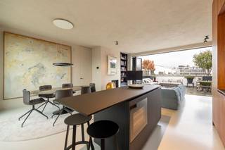 <p><span> </span></p><p><span>Luxe, rust en ruimte midden in het bruisende centrum. Dit sublieme penthouse ligt in de prestigieuze Henri Van Heurckstraat, pal tussen de Graanmarkt, het Theaterplein en het stijlvolle Botanic Sanctuary. Je wandelt zo naar de Schuttershofstraat, Mechelsplein en de leukste restaurants van de stad. Mét twee riante terrassen, hoogwaardige materialen, veel privacy, domotica en de mogelijkheid tot aankoop van twee staanplaatsen met laadpaal.</span></p><p><span> </span></p><p><span>Stijlvol & comfortabel</span></p><p><span>Je betreedt het penthouse via de modern afgewerkte veiligheidsdeur. De inkomhal met vestiaire en gastentoilet leidt je naar een lichte leefruimte met gashaard en epoxyvloer. Grote harmonicadeuren verbinden de leefruimte met het enorme terras achter en vooraan. De open keuken is uitgerust met onder andere een wijnklimaatkast, stoomoven, inductiekookplaat en extra koelkast, afgewerkt met notelaarhouten kasten en een strak werkblad.</span></p><p><span> </span></p><p><span>Rust & privacy met luxegevoel</span></p><p><span>De mastersuite heeft kamerhoge ingemaakte kasten en directe toegang tot het terras. Ensuite vind je een elegante luxe badkamer met inloopdouche, dubbele design wasbak, maatwerk spiegels en toilet. De tweede kamer doet nu dienst als bureau, maar heeft aansluitend een bergkamer met voorzieningen voor een extra badkamer. Zowel voor- als achteraan zijn er ruime terrassen (ca 60 m² & ca 12,5 m²), met uitzicht op de gemeenschappelijke binnentuin en de stad. Dankzij de slimme oriëntatie geniet je hier van licht en privacy, de hele dag door.</span></p><p><span> </span></p><p><span>Wonen tussen het theaterplein en botanische tuin</span></p><p><span>Rust, privacy én toch midden in het leven van de stad. In de Henri Van Heurckstraat woon je tussen het Theaterplein, de Meir, het Mechelseplein en het prachtige Botanic Sanctuary. Alle winkels, horeca en cultuur op wandelafstand. Openbaar vervoer (metro Meir, tram op de Leien en Centraal Station) bereik je binnen de 5 minuten te voet.</span></p><p><span> </span></p><p><span>Maatregelenregister: in aanvraag</span></p><p><span> </span></p>