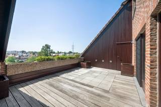 Bent u op zoek naar een uitzonderlijk ruim appartement met het gevoel van een woning? Dan is dit prachtige triplex penthouse, gelegen op de vierde, vijfde en zesde verdieping van een verzorgde residentie aan de Tramweglei 45 in Lier, beslist een bezoek waard. Deze triplex is bereikbaar met de lift. Dankzij de centrale ligging bevindt u zich op wandelafstand van winkels, openbaar vervoer en andere dagelijkse voorzieningen, terwijl u geniet van een open uitzicht en alle rust.<br /><br />Via de inkomhal met gastentoilet betreedt u de royale leefruimte, afgewerkt met een parketvloer en grote raampartijen die zorgen voor een aangename lichtinval. Aansluitend vindt u de volledig uitgeruste keuken, voorzien van een oven, kookplaat, koelkast, diepvriezer, vaatwasser en dubbele spoelbak. Verder beschikt deze verdieping over een praktische technische berging. Vanuit de leefruimte heeft u toegang tot het zonnige terras van 24,6 m², afgewerkt in hout en voorzien van een water- en elektriciteitsaansluiting. Hier geniet u in alle privacy van een prachtig open uitzicht.<br /><br />De volgende verdieping beschikt over een slaapkamer van 16m², voorzien van parket en ingemaakte kasten, alook de dressing met maatkasten. Verder bevindt zich op deze verdieping een stijlvolle badkamer met dubbele lavabo, ruime inloopdouche en toilet, aangevuld met een aparte technische berging.<br /><br />Via een vaste trap bereikt u de laatste verdieping, waar zich een polyvalente ruimte van 24 m² bevindt. Deze ruimte leent zich perfect slaapkamer, bureau of hobbyruimte en beschikt bovendien over een wateraansluiting, wat tal van mogelijkheden biedt.<br /><br />Tot slot beschikt het appartement over een privatieve garagebox, wat het wooncomfort compleet maakt.<br /><br />Troeven<br />+ Lift<br />+ Groot zonneterras<br />+ 2 slaapkamers<br />+ Dressing en ingemaakte kasten<br />+ Privatieve garagebox<br />+ Centrale ligging nabij centrum, winkels en openbaar vervoer<br /><br />Interesse in deze unieke triplex penthouse? Contacteer ons via 03 337 50 70 of info@vbvastgoed.be voor meer informatie of een bezoek ter plaatse.