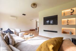 <p><strong>Ontdek deze ruime, recent gerenoveerde villa die gelegen is op een prachtig perceel van maar liefst 2.430 m² met ideale zuidwestoriëntatie, waar u in alle rust en privacy geniet van zon en groen. De villa omvat o.a. een lichtrijke woonkamer op parket met zithoek en eethoek, aansluitend een hoogwaardig vernieuwde keuken, die voorzien werd van alle moderne apparatuur, met tuinzicht en berging/wasruimte. Gelijkvloers 3 slaapkamers en een moderne badkamer. Verdieping met 2 ruime slaapkamers, tweede badkamer en polyvalente ruimte. Dubbele inpandige garage. Energiezuinig met EPC B, zonnepanelen, warmtepomp (airco) en recente isolatiewerken. Instapklaar met onderhoudsvriendelijke tuin en ruime parkeermogelijkheden.</strong></p>
<p><span>Indeling gelijkvloers</span><br />Bij het binnenkomen via de royale inkomhal met gastentoilet en vestiaire ervaart u meteen de logische indeling en het aangename ruimtegevoel. Vanuit de hal wordt de woning mooi opgedeeld tussen leef- en nachtgedeelte.</p>
<p>Aan de linkerzijde bevindt zich de lichtrijke woonkamer op parket, stijlvol ingedeeld in een gezellige zithoek/tv-hoek en een ruime eethoek. De aansluitende, volledig vernieuwde keuken biedt een mooi zicht op de tuin en is praktisch ingericht. Via de keuken bereikt u de berging/wasruimte, met toegang tot de kelder én een bijkomende trap naar de verdieping.</p>
<p>Aan de rechterzijde van de inkomhal bevindt zich het nachtgedeelte op het gelijkvloers. Hier vindt u een recent gerenoveerde badkamer, uitgerust met een ruime inloopdouche, ligbad en toilet. Verder zijn er drie volwaardige slaapkamers, waarvan één momenteel ingericht is als bureau. Op het einde van de hal bereikt u de ruime dubbele garage met twee sectionaalpoorten.</p>
<p><span>Verdieping</span><br />Op de volledig afgewerkte verdieping bevinden zich nog twee bijzonder ruime slaapkamers en een tweede badkamer met douche en toilet. Tussen beide kamers bevindt zich een polyvalente ruimte, ideaal als bureau, speelkamer of hobbyruimte.</p>
<p>De woning werd bovendien energetisch geoptimaliseerd met zonnepanelen, warmtepomp (airco) en recente isolatiewerken, wat resulteert in een gunstig EPC-label B. Het dak werd tevens gerenoveerd.</p>
<p>De buitenruimte vormt een absolute meerwaarde: het ruime perceel biedt tal van mogelijkheden, voldoende parkeergelegenheid en een ideale zuidwestoriëntatie om maximaal te genieten van zon, rust en privacy.</p>
<p><span>Bijzonderheden:</span></p>
- Instapklare, ruime villa (430m²) met 5 slaapkamers<br />- Gelijkvloers wonen mogelijk<br />- Duurzaam – gunstig EPC<br />- Onderhoudsvriendelijke tuin<br />- Dubbele, inpandige garage<br />- Zonnepanelen<br />- Airco (warmtepomp)<br />- Laadpaal (3-fase - 22kw mogelijk)