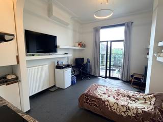 Deze zeer kwalitatief afgewerkte studio bevindt zich aan de achterzijde van het gebouw waardoor het zeer rustig wonen is, dicht bij centrum en station Leuven.<br />De studio omvat een inkomhal met praktische (vestiaire)kasten, een gezellige leef- en slaapruimte met open keuken en toegang tot een aangenaam terrasje. De badkamer is uitgerust met een wastafel, douche en toilet.<br />Daarnaast beschikt de studio over een aparte kelderberging. In de kelderverdieping is er tevens de mogelijkheid om een wasmachine te plaatsen.  Bereikbaar via de lift.<br />Beschikbaar vanaf 1 november 2026.<br />Een ideale woonst voor wie comfortabel en rustig wil wonen, met alle voorzieningen en het centrum van Leuven binnen handbereik.