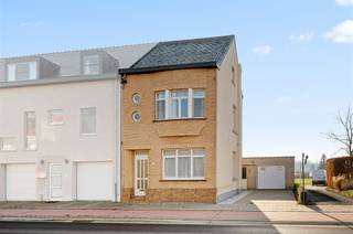 Celui qui s'engage dans l'allée de cette maison remarque que les façades sont jolies, avec des fenêtres décoratives rondes et une baie vitrée...