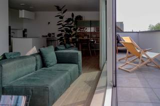 PENTHOUSE | ZUIDTERRAS | 3 SLAAPKAMERS | AUTOSTAANPLAATS MET LAADPAAL<br /><br />In de opkomende buurt de Muide bevindt zich op de derde verdieping dit stijlvol en tijdloos ingericht penthouse, afgewerkt met duurzame en kwalitatieve materialen. De combinatie van hedendaags comfort, slimme technologie en een rustige ligging op korte afstand van het centrum maakt dit een uitzonderlijk aangename woonplek.<br /><br />De inkomhal met vestiaire geeft toegang tot de lichtrijke leefruimte met grote raampartijen en een open indeling. De moderne open keuken met kookeiland is volledig uitgerust met kwalitatieve toestellen, waaronder een Novy Mood dampkap, en sluit perfect aan bij de eet- en zithoek – ideaal voor wie houdt van koken en gezellig samenzijn.<br /><br />De woonkamer beschikt bovendien over een ingebouwde beamer, wat zorgt voor een volwaardige home cinema-ervaring.<br /><br />Er zijn drie slaapkamers, waarvan één voorzien is van een grote op maat gemaakte inbouwkast. In een andere is er een op maat gemaakte bureauruimte, perfect voor thuiswerk. De ruime badkamer is praktisch ingericht en afgewerkt met duurzame materialen.<br /><br />Het penthouse beschikt over een zuidgericht terras van ca. 20 m², waar het heerlijk vertoeven is in alle rust. Verder zijn er zowel een private kelderberging als een extra berging op het verdiep.<br /><br />Bij het appartement hoort een ondergrondse autostaanplaats met Smappee laadpaal, ideaal voor elektrisch rijden.<br /><br />Het gebouw dateert van 2020 en heeft een uitstekend energiepeil (EPC A – 58 kWh/m²). Dankzij de aanwezigheid van Nest verwarming, slimme deurbel en geïntegreerde multimedia is het penthouse volledig future-proof.<br /><br />Kortom:<br />✔ 110 m² bewoonbare oppervlakte<br />✔ Zuidgericht terras van ca. 20 m²<br />✔ Op maat gemaakte bureau en inbouwkasten<br />✔ Open keuken met kookeiland en kwalitatieve toestellen<br />✔ Parkettegel in het volledige appartement<br />✔ Autostaanplaats met Smappee laadpaal<br />✔ Bouwjaar 2020 – EPC A (58 kWh)<br />✔ Slimme woning: Nest verwarming & slimme deurbel<br /><br /><br />Interesse of bezoek? hello@dok19.be