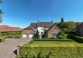 <p><strong>Exclusieve, luxueus afgewerkte villa op toplocatie nabij de Nederlandse grens</strong></p>
<p><strong>Deze uitzonderlijk ruime en perfect onderhouden villa (bouwjaar 2001) is gelegen op een prachtig perceel van ca. 1.383 m² en biedt een indrukwekkende bewoonbare oppervlakte van circa 474 m² (inhoud ca. 1.500 m³). De woning combineert comfort, luxe en privacy op hoog niveau en is ideaal voor wie ruim en stijlvol wil wonen in een groene, centrale omgeving.</strong></p>
<p><strong>De villa beschikt over onder andere 4 slaapkamers, royale leefruimtes, een stijlvolle woonkeuken met kookeiland, een dubbele inpandige garage én een grote zolder met uitbreidingsmogelijkheden. Bovendien is de woning uitgerust met een alarmsysteem en een centraal stofzuigersysteem, wat bijdraagt aan extra comfort en veiligheid. Energielabel: B.</strong></p>
<p>Gelijkvloers</p>
<p>Via de imposante inkomhal met gastentoilet betreedt u de woning. Hier ervaart u direct de ruimte en het hoogwaardige afwerkingsniveau. De sfeervolle woonkamer met gashaard vormt het warme hart van de woning en biedt een prachtig zicht op de tuin. Aansluitend bevindt zich een afsluitbare tv-kamer of bureau – ideaal voor thuiswerken of ontspanning.</p>
<p>De royale woonkeuken met kookeiland is voorzien van kwalitatieve inbouwapparatuur en vormt de perfecte plek voor gezellige momenten met familie en vrienden. Aan de achterzijde van de woning vindt u de praktische bijkeuken met aansluitingen voor wasapparatuur, een extra kantoorruimte en toegang tot de dubbele inpandige garage met automatische poorten.</p>
<p>Eerste verdieping</p>
<p>Op de eerste verdieping bevinden zich drie ruime slaapkamers. De indrukwekkende masterbedroom (ca. 45 m²) beschikt over een eigen inloopkast en aangrenzende dressing – een ware privé suite.</p>
<p>De luxe badkamer is compleet uitgerust met een dubbele wastafel met meubel, een ligbad en een comfortabele inloopdouche. Daarnaast is er op de overloop een separaat toilet aanwezig. Via een vaste trap bereikt u de tweede verdieping.</p>
<p>Tweede verdieping</p>
<p>De ruime zolderverdieping biedt tal van mogelijkheden en kan eenvoudig worden ingericht met extra (slaap)kamers, een hobbyruimte of fitnessruimte.</p>
<p>Buitenleven</p>
<p>De fraai aangelegde tuin biedt optimale privacy en is een waar verlengstuk van de woning. U geniet hier van meerdere terrassen en een sfeervolle overkapping met buitenhaard – perfect voor lange avonden in alle seizoenen. Aansluitend bevindt zich een praktische schuur.</p>
<p>Aan de voorzijde beschikt de woning over een verzorgde voortuin en een ruime oprit met parkeergelegenheid voor meerdere auto’s.</p>
<p>Kortom: een instapklare, luxueuze villa met uitzonderlijk veel ruimte, comfort en privacy op een uitstekende locatie. Een unieke kans voor wie exclusief wil wonen!</p>
<span>Bijzonderheden</span><br /><span>- EPC B</span><br /><span>- vloerverwarming<br /></span>- ruime kelder op stahoogte<br /><span>- centraal stofzuigersysteem</span><br /><span>- centrale ligging nabij scholen/winkels en Nederlandse grens</span><br /><span>- luxe afwerking</span>